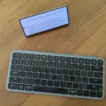 Bàn phím Bluetooth kết nối với điện thoại Galaxy Z Fold 6 đang đặt trên chân đế.