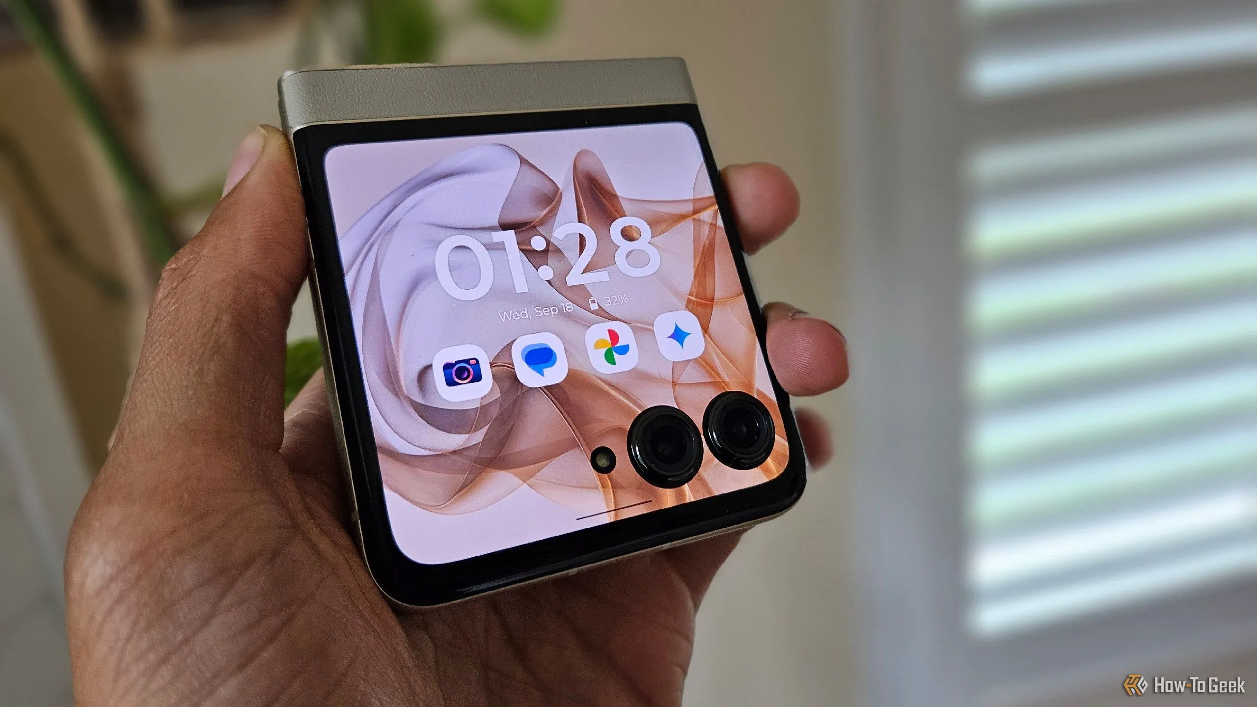 Bàn tay đang cầm điện thoại Motorola Razr 2024 ở trạng thái gập, thể hiện kích thước thực tế của một chiếc flip phone khi thu gọn