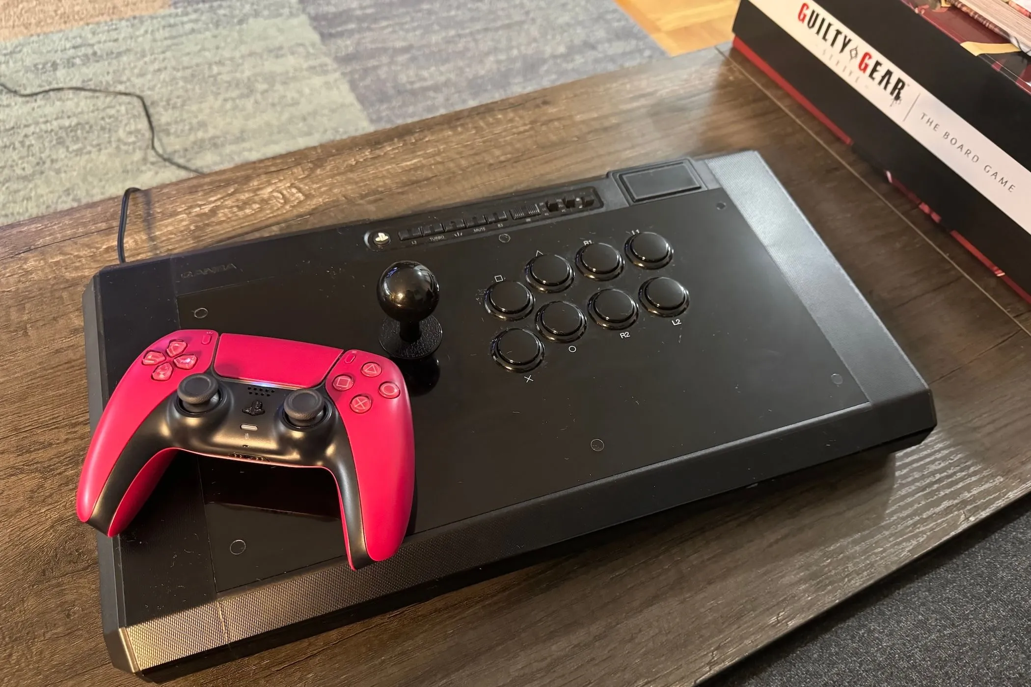 Bộ điều khiển DualSense của PlayStation 5 đặt cạnh một cần gạt arcade (fight stick)