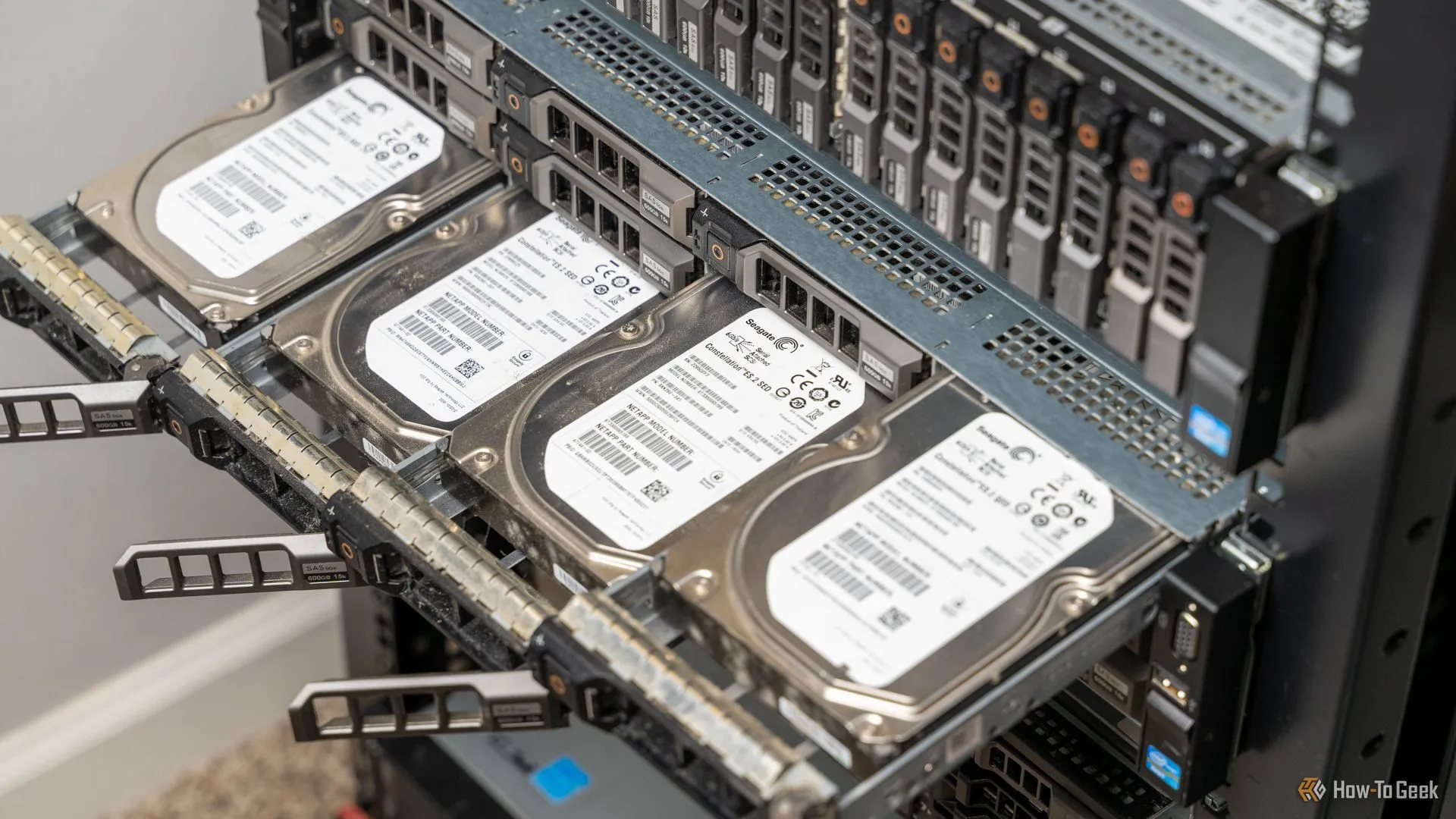 Bốn ổ cứng (hard drive) nhô ra từ một máy chủ gắn rack, tượng trưng cho nơi lưu trữ dữ liệu sao lưu quan trọng của server Minecraft để phòng tránh sự cố.