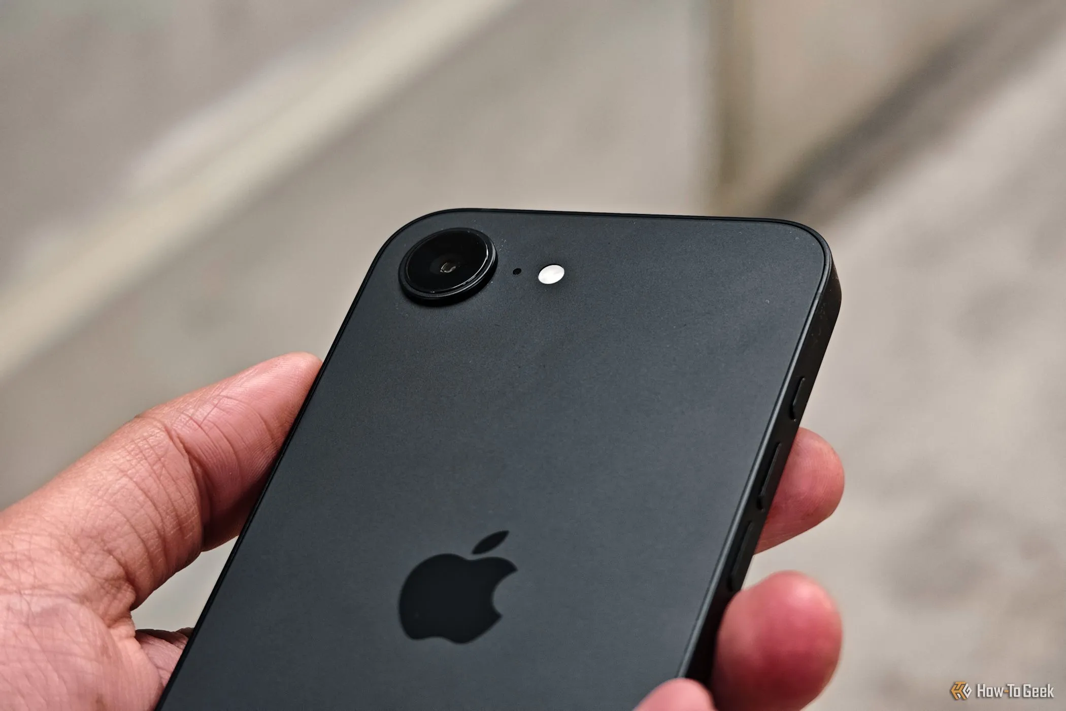 Cận cảnh cụm camera của iPhone 16e trong tay người dùng, nổi bật ống kính chính 48MP.