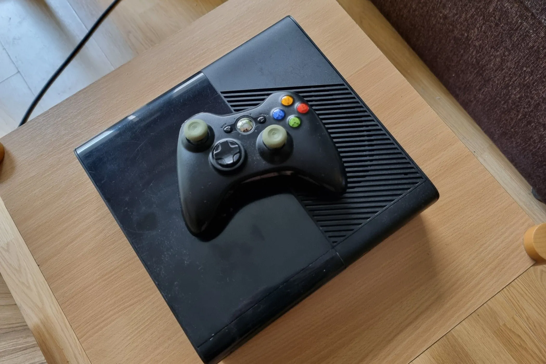Cận cảnh một chiếc Xbox 360 cũ và tay cầm, biểu tượng cho khả năng tương thích ngược với các tựa game Xbox đời đầu.
