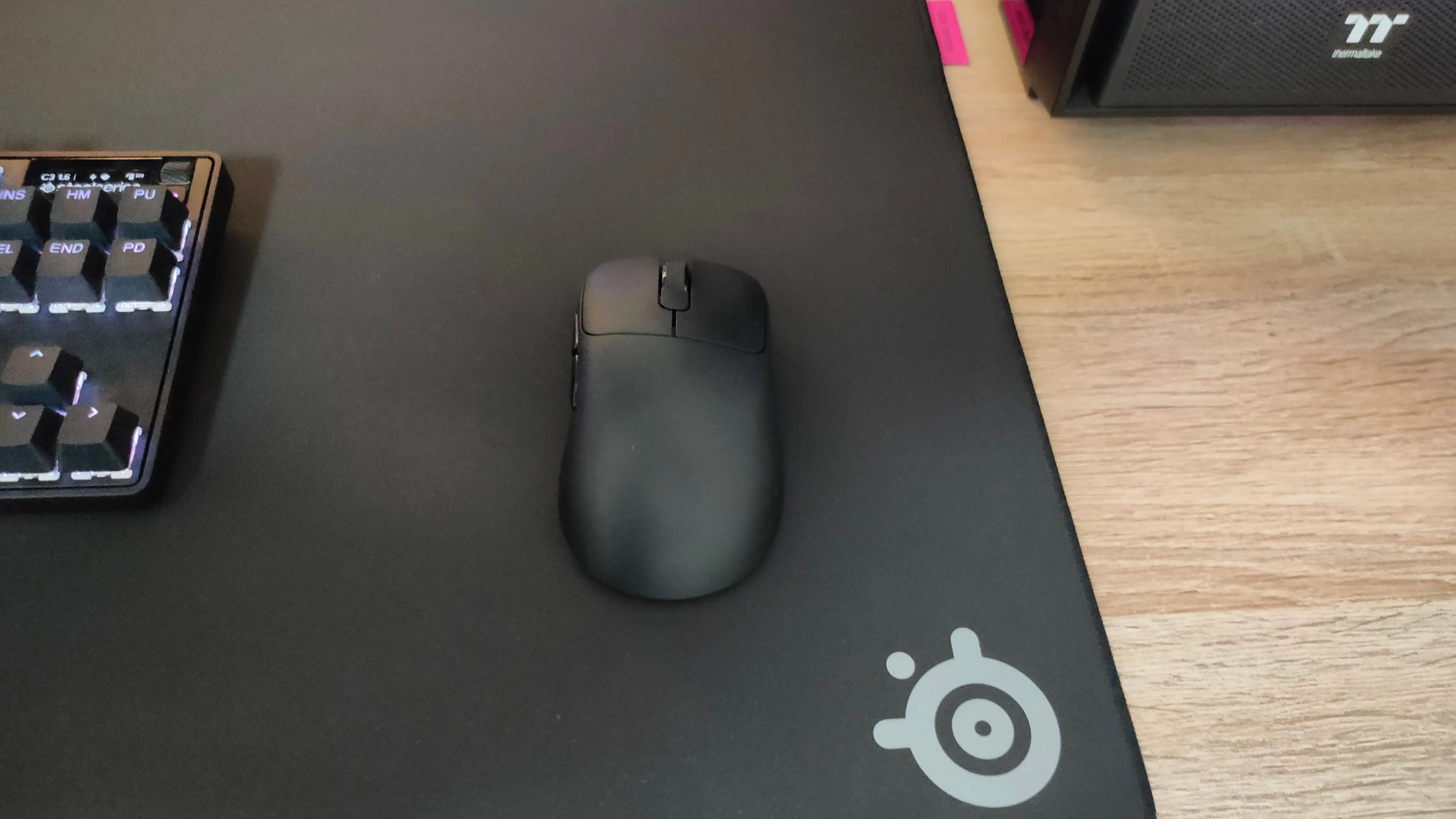 Chuột gaming siêu nhẹ Ajazz AJ179 Pro đặt trên tấm lót chuột SteelSeries QcK Performance Speed màu đen, thể hiện độ trượt mượt mà.