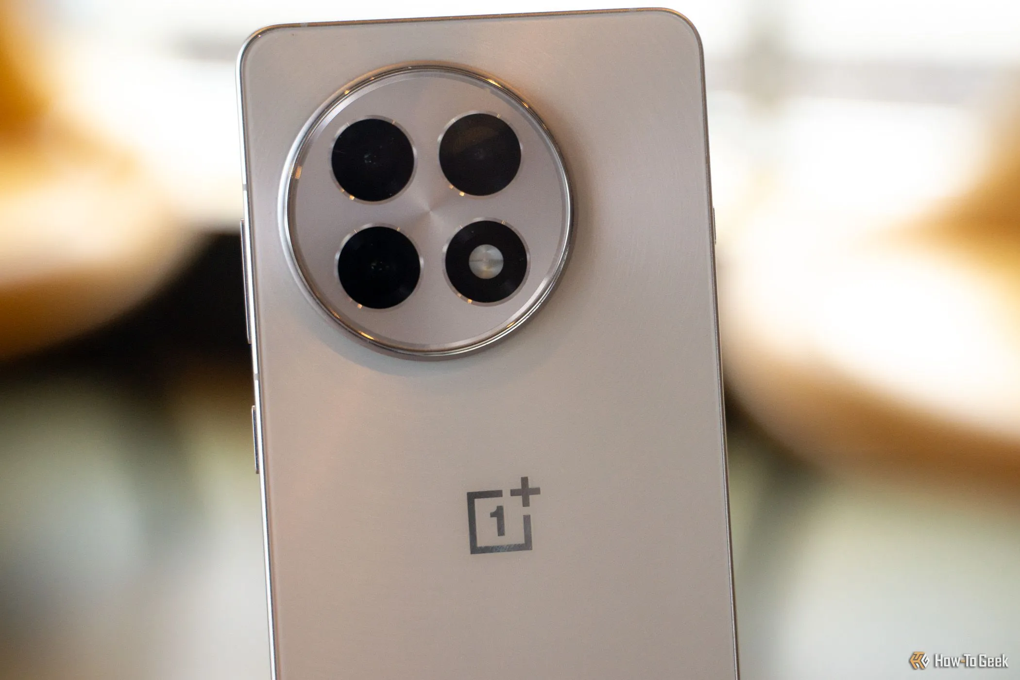 Cụm ba camera sau của OnePlus 13R, cho thấy sự khác biệt so với camera đơn của iPhone 16e.