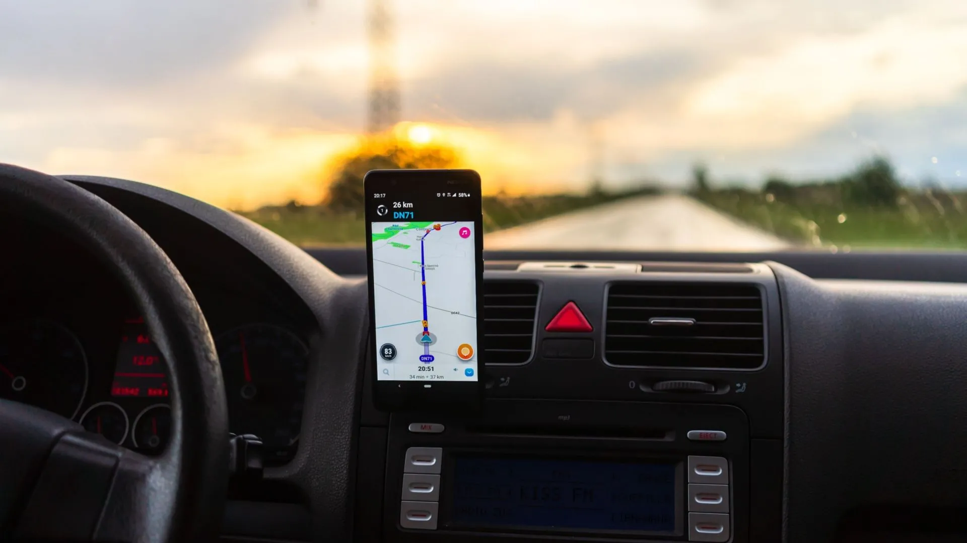 Điện thoại Android gắn trên giá đỡ, hiển thị ứng dụng bản đồ trên bảng điều khiển xe hơi.