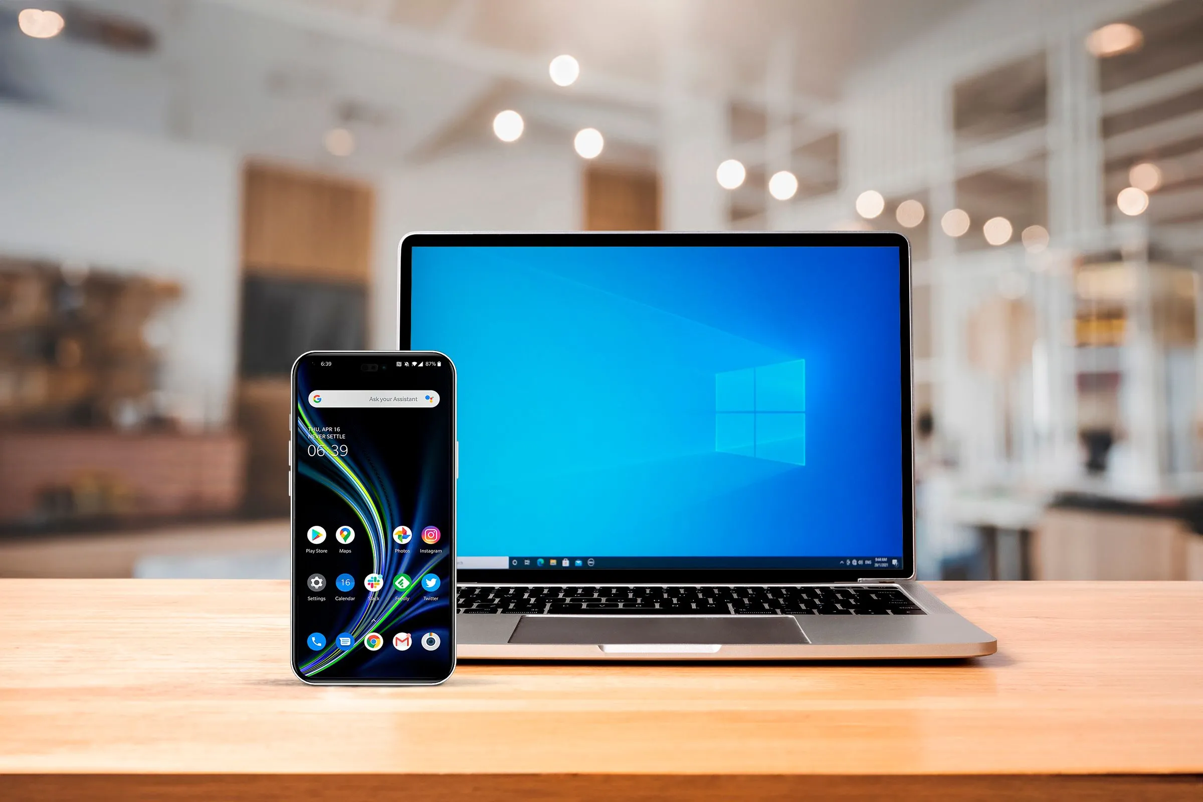 Điện thoại Android và laptop Windows trên bàn làm việc, biểu tượng cho khả năng đồng bộ thiết bị