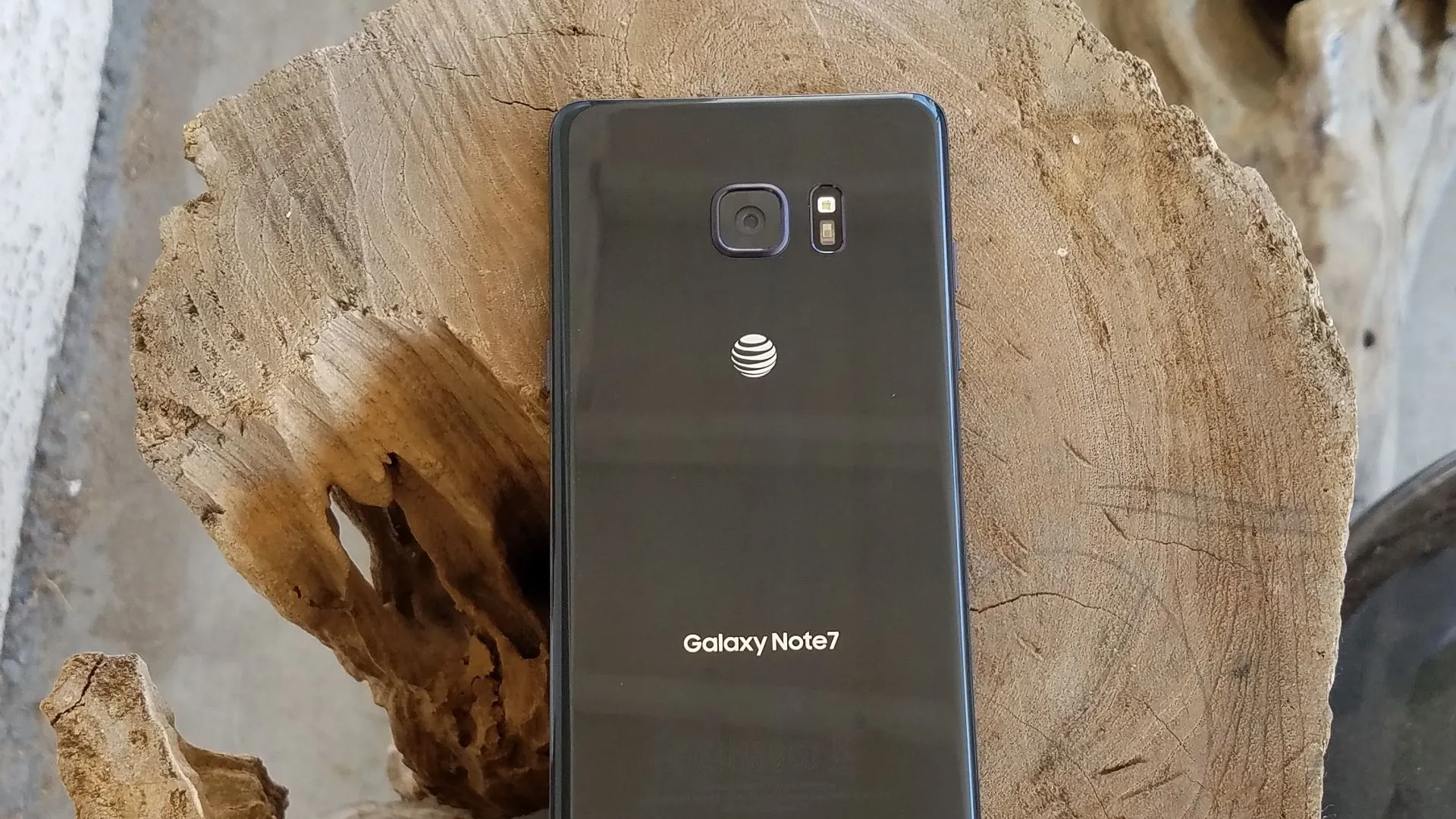 Điện thoại Samsung Galaxy Note 7 màu đen với màn hình cong ấn tượng đặt trên khối gỗ