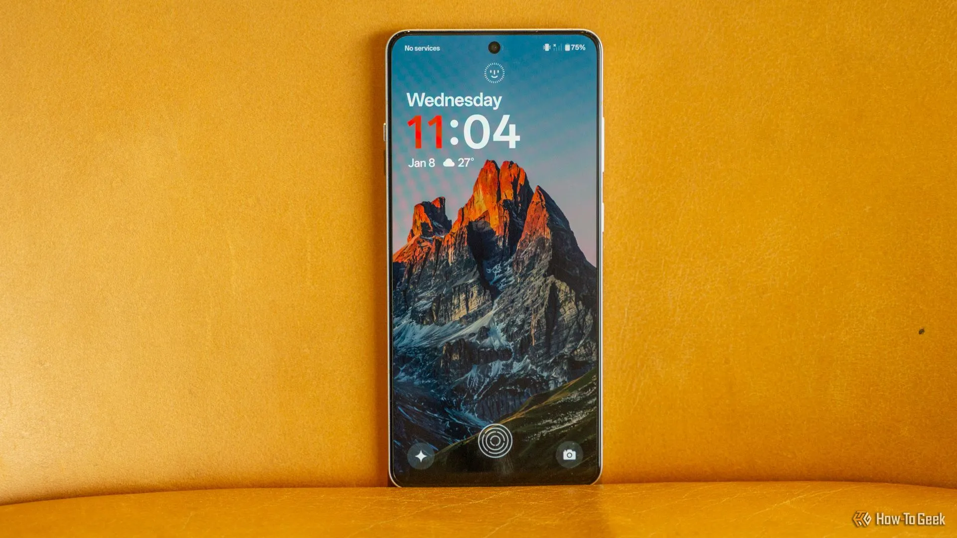 Điện thoại thông minh Android OnePlus 13R với màn hình khóa hiển thị, đặt trên ghế da.