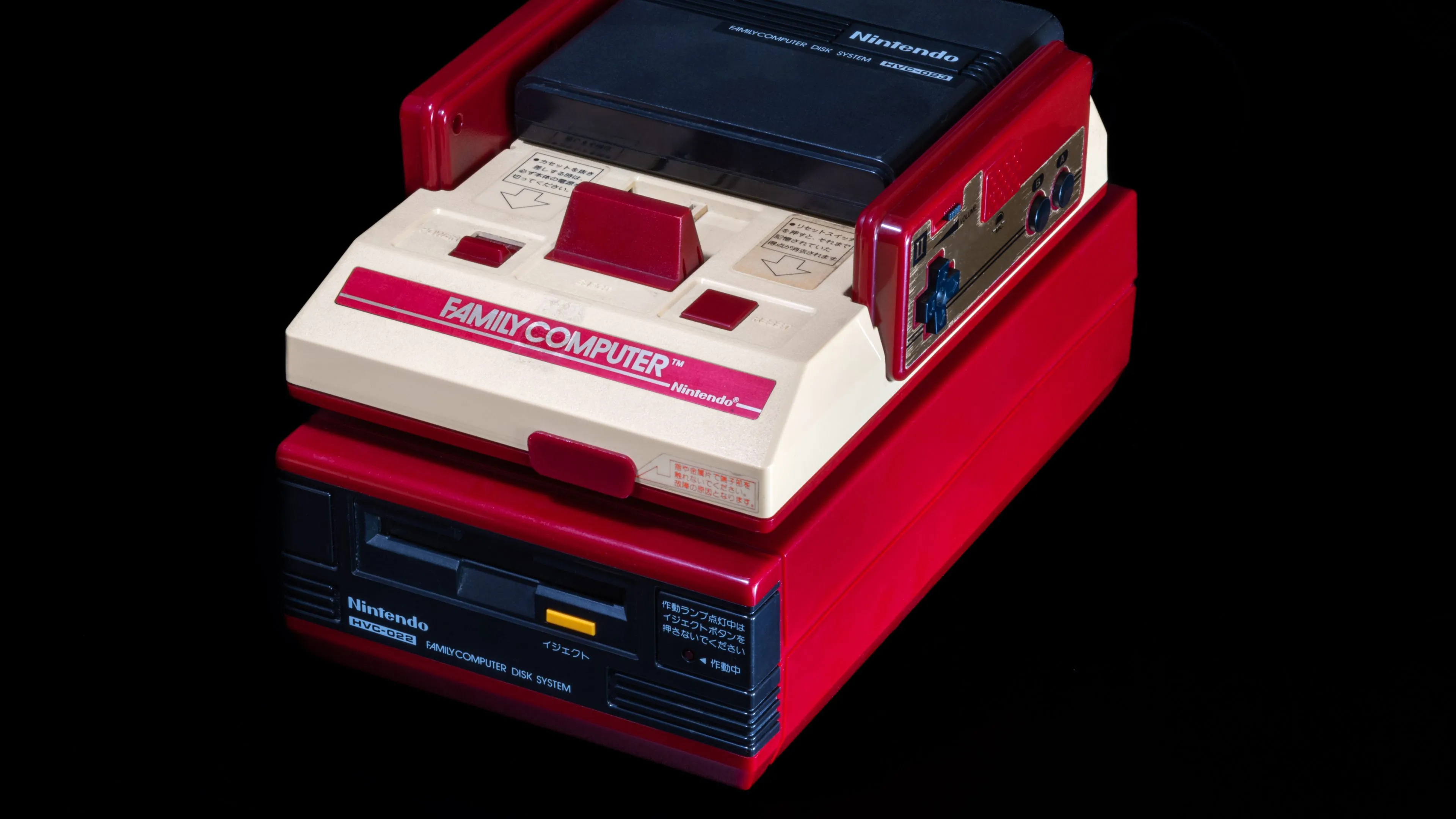 Hệ máy Nintendo Famicom màu đỏ và trắng kết nối với hệ thống đĩa Famicom (FDS).