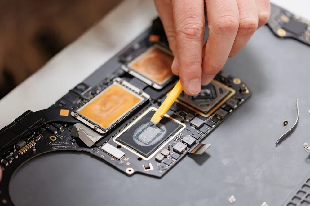Kỹ thuật viên đang làm việc với MacBook, minh họa chi phí nhân công sửa chữa