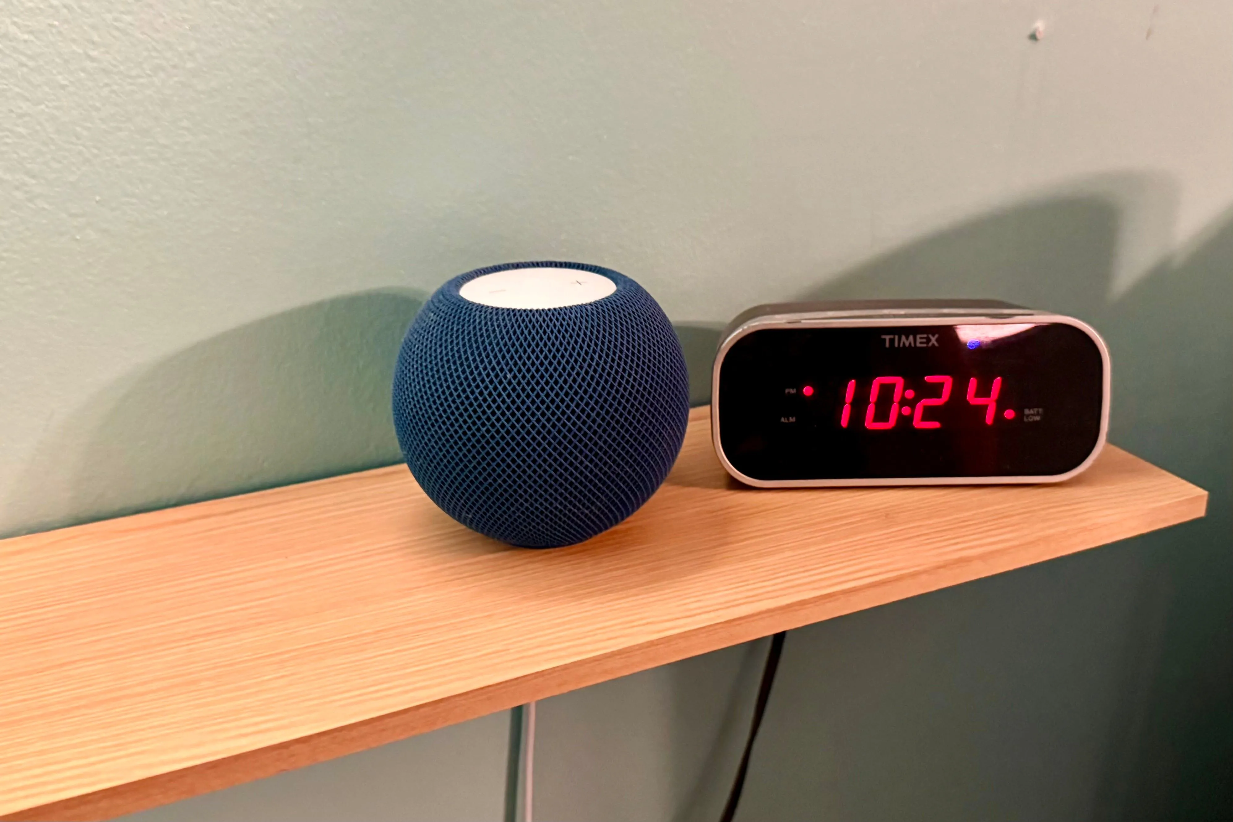 Loa thông minh HomePod mini trên kệ, cho phép người dùng tìm thiết bị Apple bằng cách ra lệnh giọng nói qua Siri.