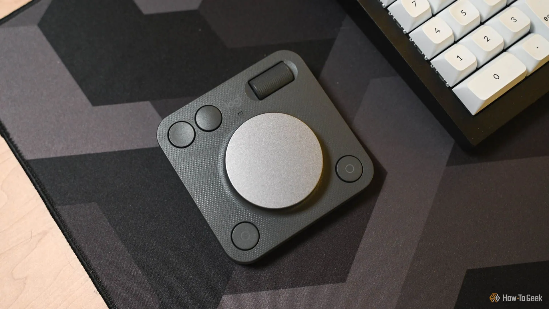 Logitech MX Creative Dialpad đặt cạnh bàn phím máy tính, minh họa vị trí sử dụng trên bàn làm việc