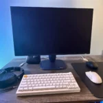 Màn hình Alienware 27 4K QD-OLED (AW2725Q) trên bàn làm việc cùng các thiết bị PC và gaming khác.