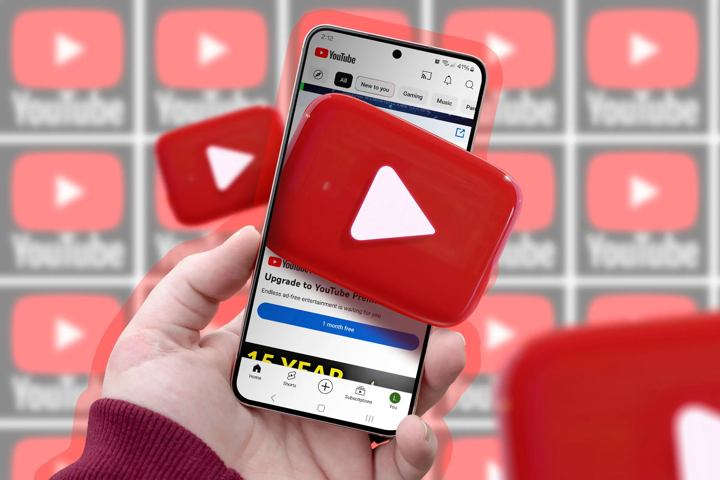 Một bàn tay cầm điện thoại hiển thị ứng dụng YouTube, biểu tượng YouTube nổi bật trên màn hình và trong nền, tượng trưng cho tính năng playlist cộng tác mới.
