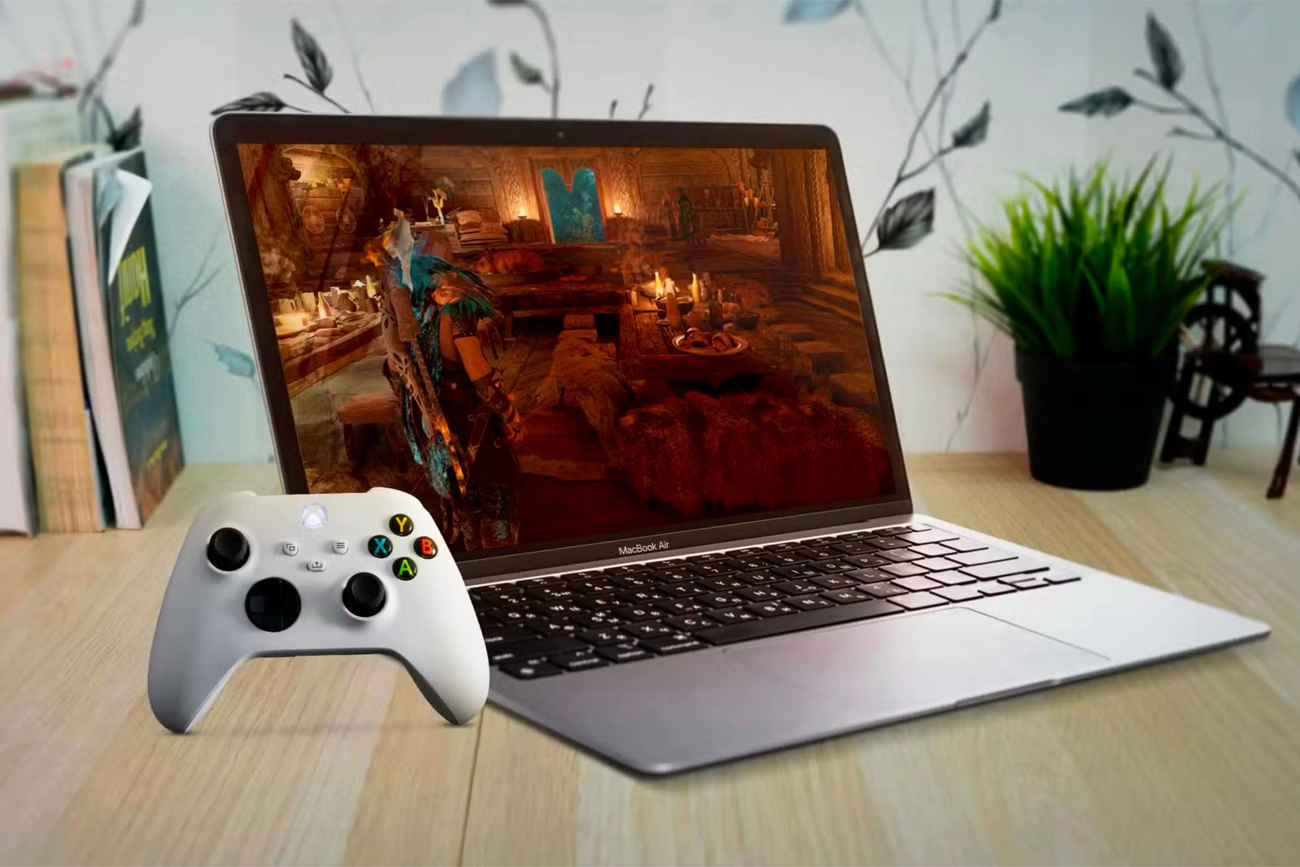 Một chiếc MacBook Air đang hiển thị trò chơi điện tử, bên cạnh tay cầm Xbox, thể hiện trải nghiệm chơi game của người dùng trên Mac