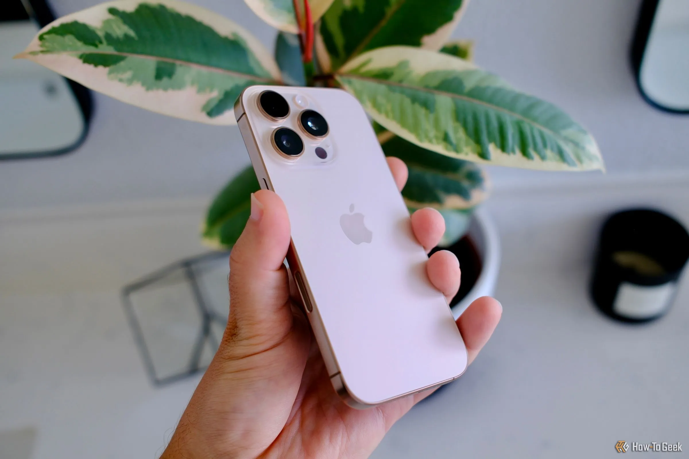 Người dùng đang cầm chiếc điện thoại iPhone 16 Pro, minh họa trải nghiệm sử dụng ứng dụng di động