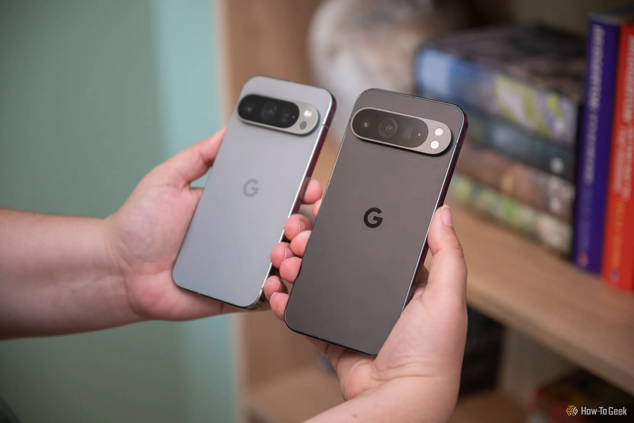 Người dùng đang cầm điện thoại Google Pixel 9 Pro và 9 Pro XL.