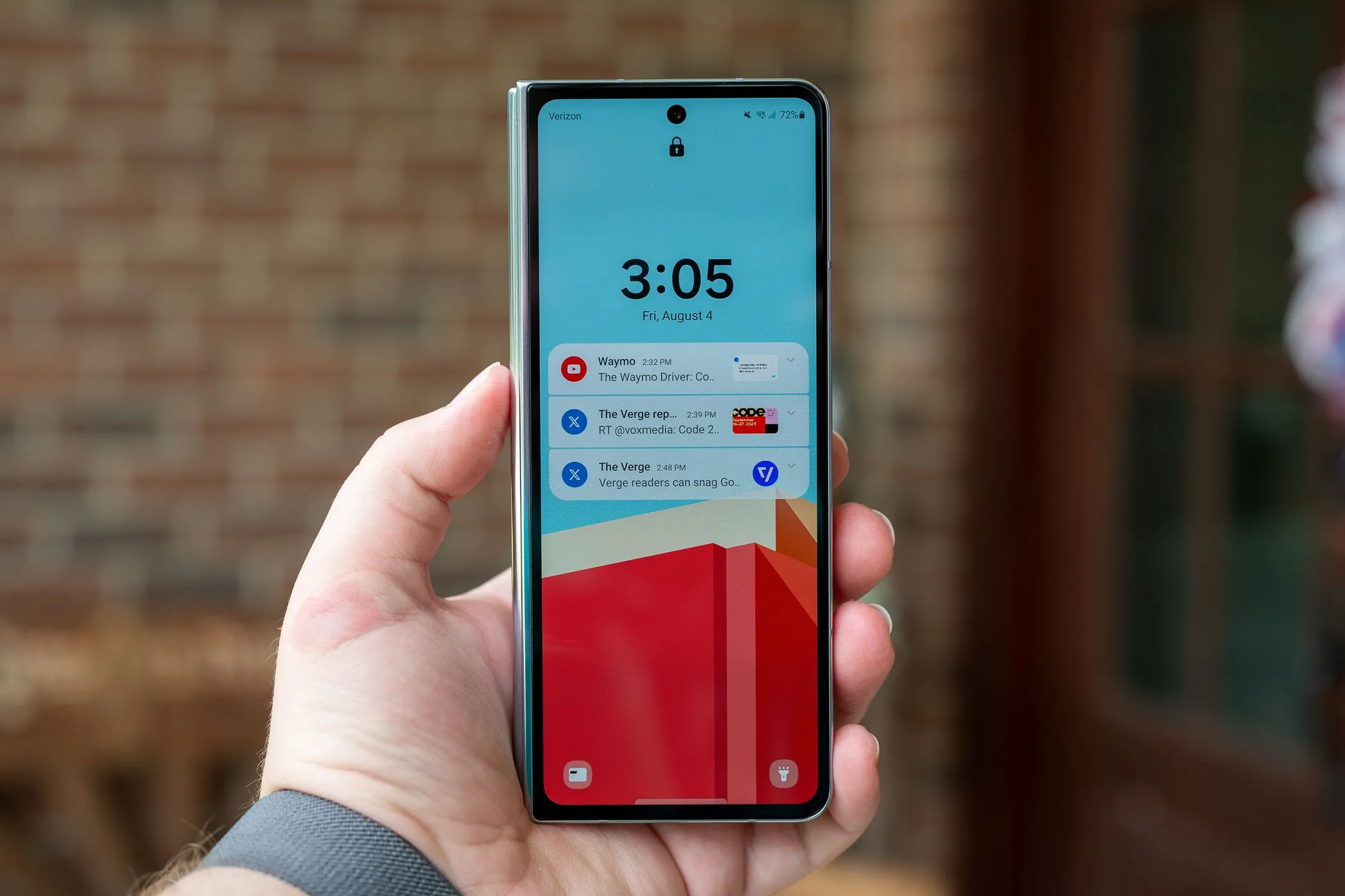 Người dùng đang cầm điện thoại Samsung Galaxy Z Fold 5 với màn hình khóa bật sáng, tượng trưng cho một thiết bị Android có thể sử dụng Notification Cooldown.