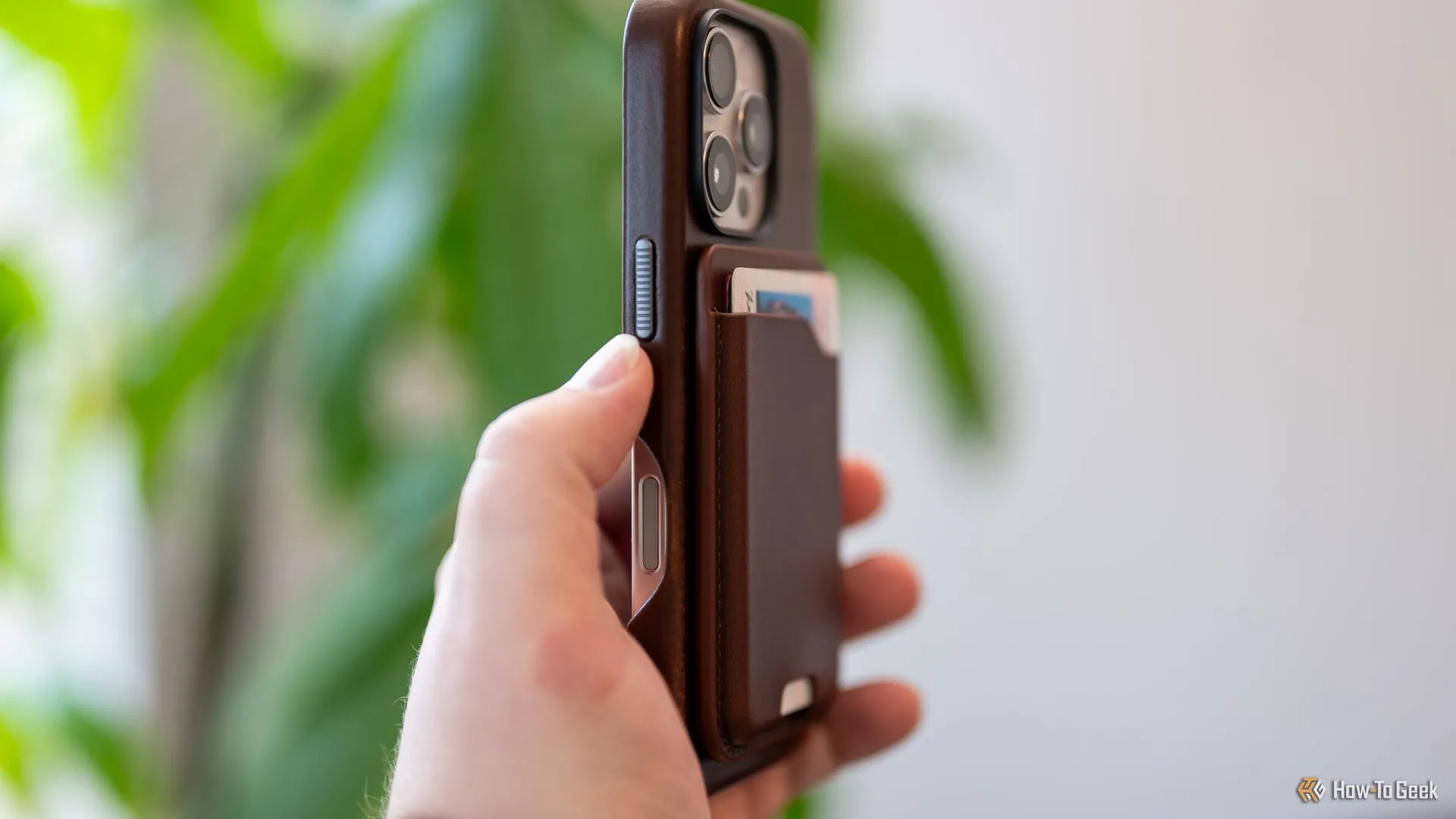 Người dùng trải nghiệm ví da Nomad Leather Mag Wallet gắn chắc chắn vào iPhone qua MagSafe.