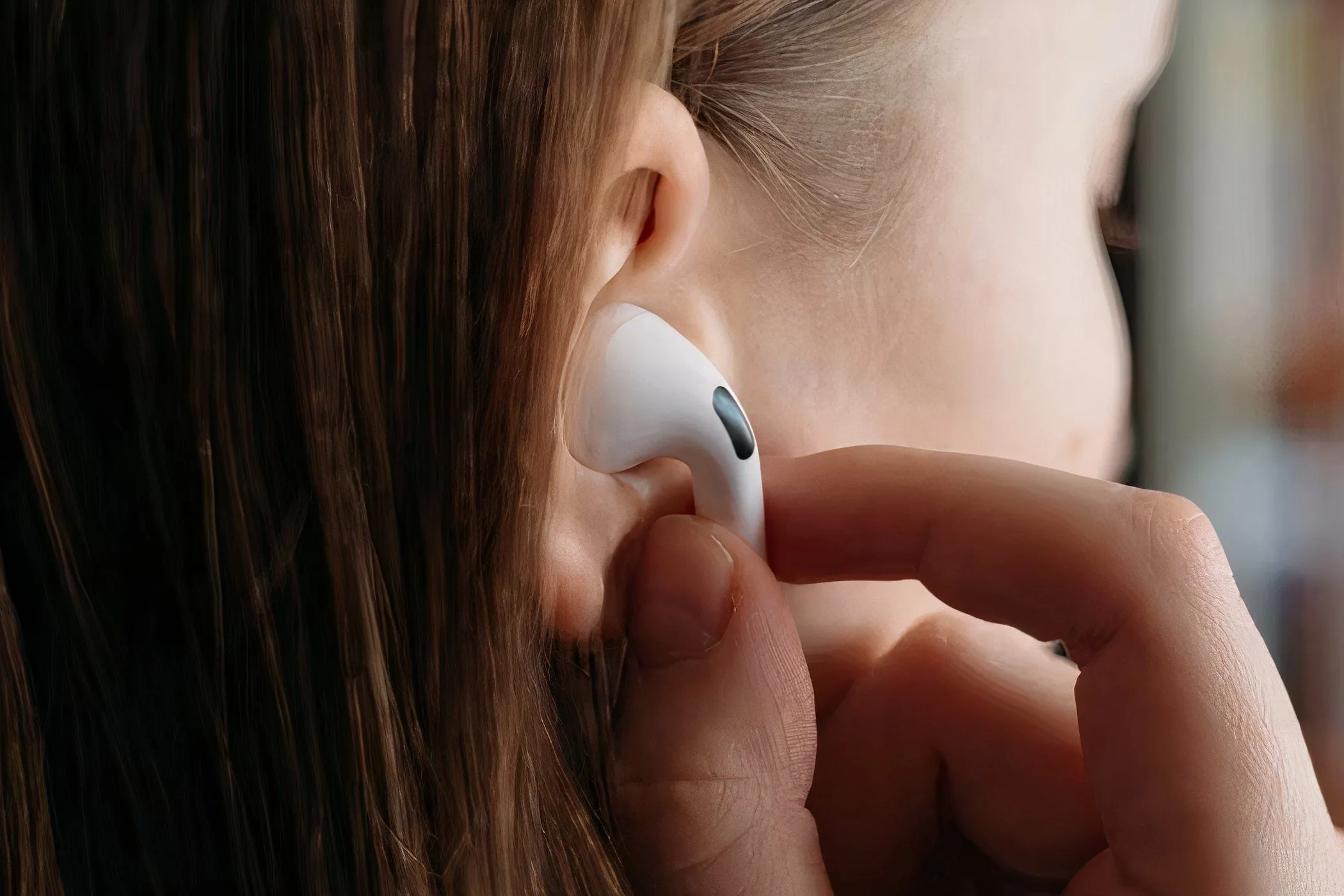 Người phụ nữ đang đeo AirPods Pro vào tai, thể hiện sự tiện lợi của tai nghe không dây