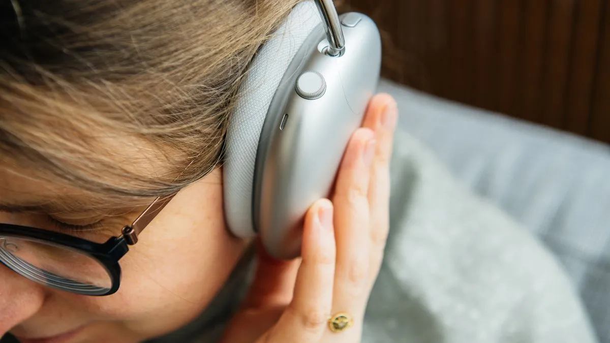Người phụ nữ đeo tai nghe over-ear, minh họa chế độ xuyên âm hoặc chống ồn