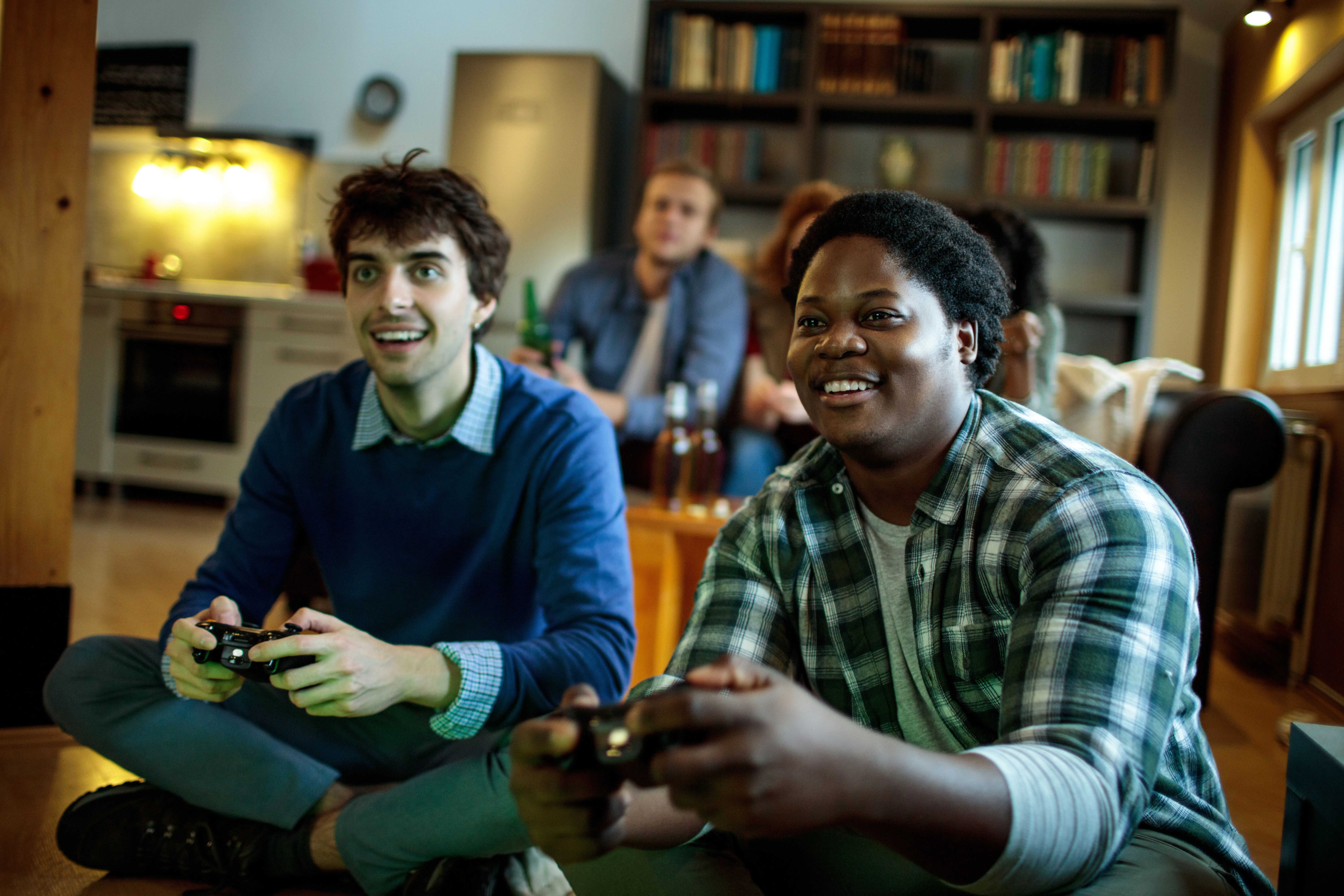 Nhóm bạn trẻ đang chơi game co-op nhiều người trên console tại phòng khách.