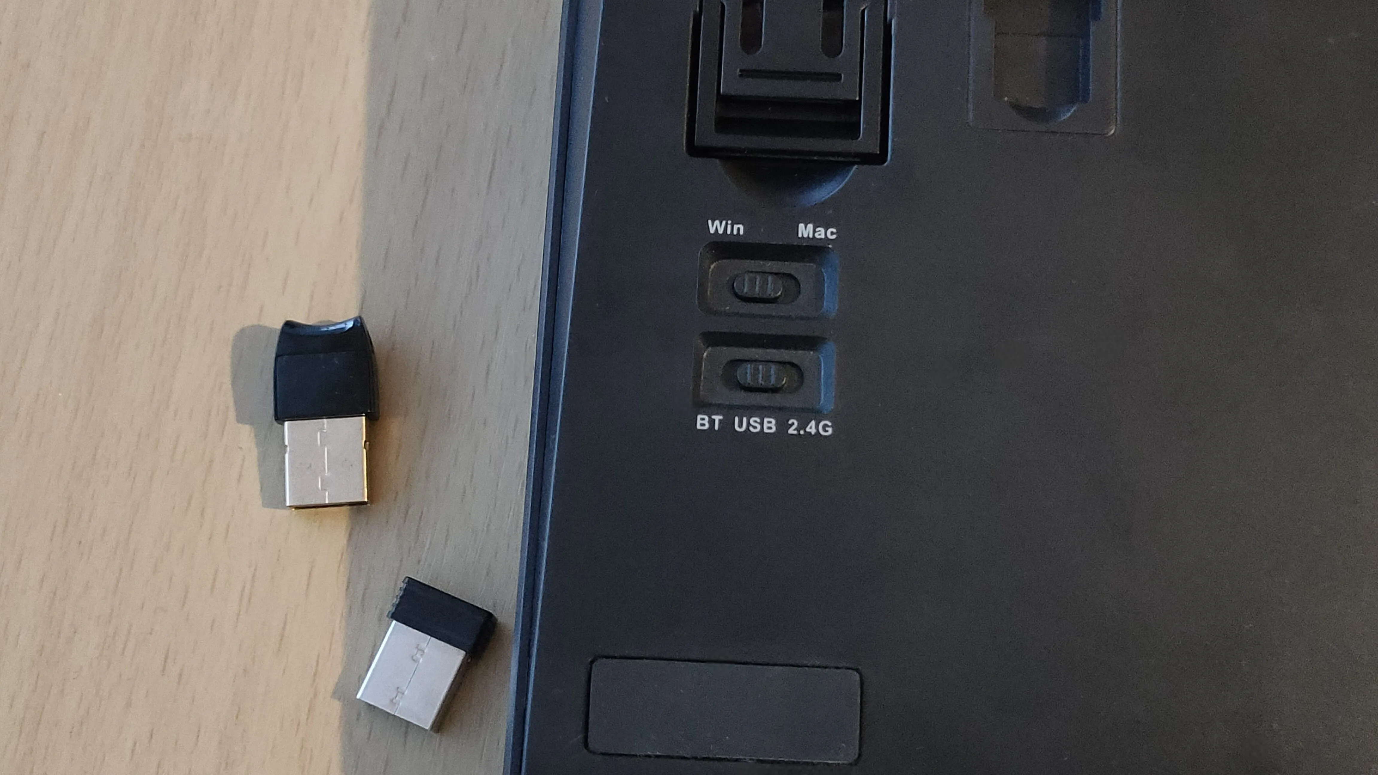 Nút chuyển đổi chế độ kết nối Bluetooth / USB / 2.4G và dongle USB 2.4GHz trên một bàn phím.