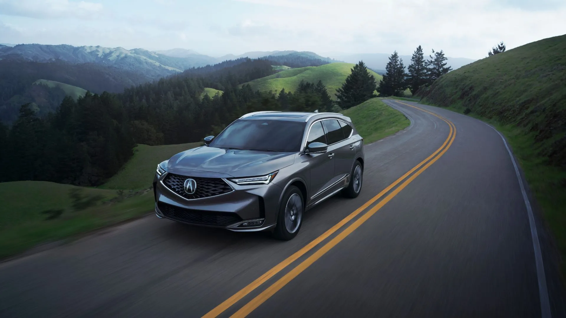 Acura MDX 2025 màu trắng bạc trên đường quê, minh họa sự kết hợp giữa tính năng lái thể thao và an toàn