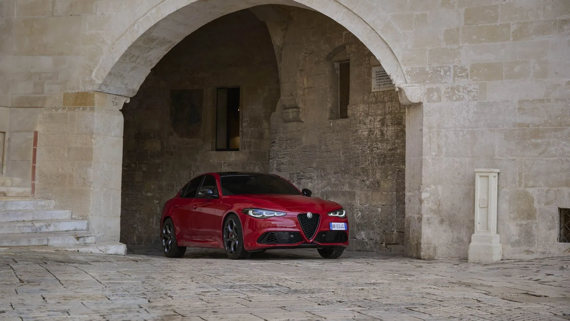 Alfa Romeo Giulia 2025 màu đỏ rực, góc 3/4 phía trước, biểu tượng của sự sang trọng và thể thao Ý