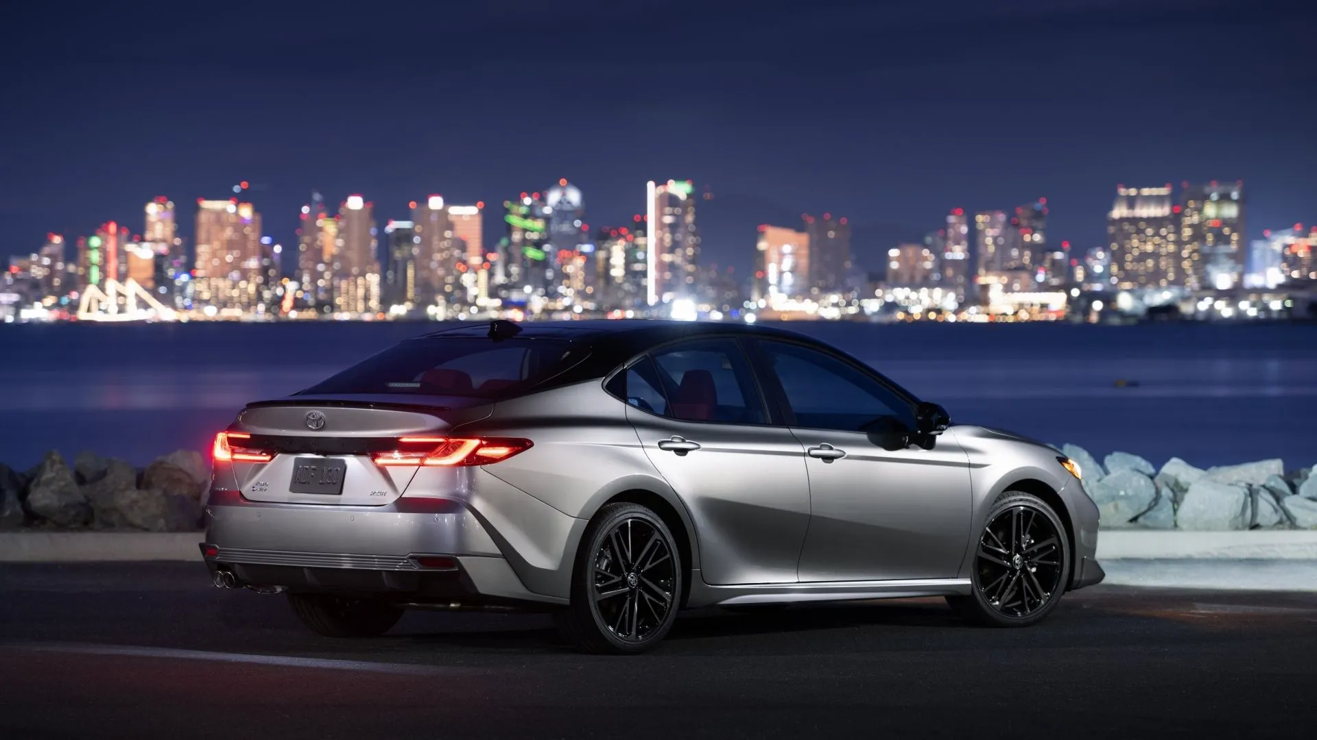 Ảnh góc 3/4 phía sau của Toyota Camry 2025 XSE AWD với nóc xe màu đen sang trọng