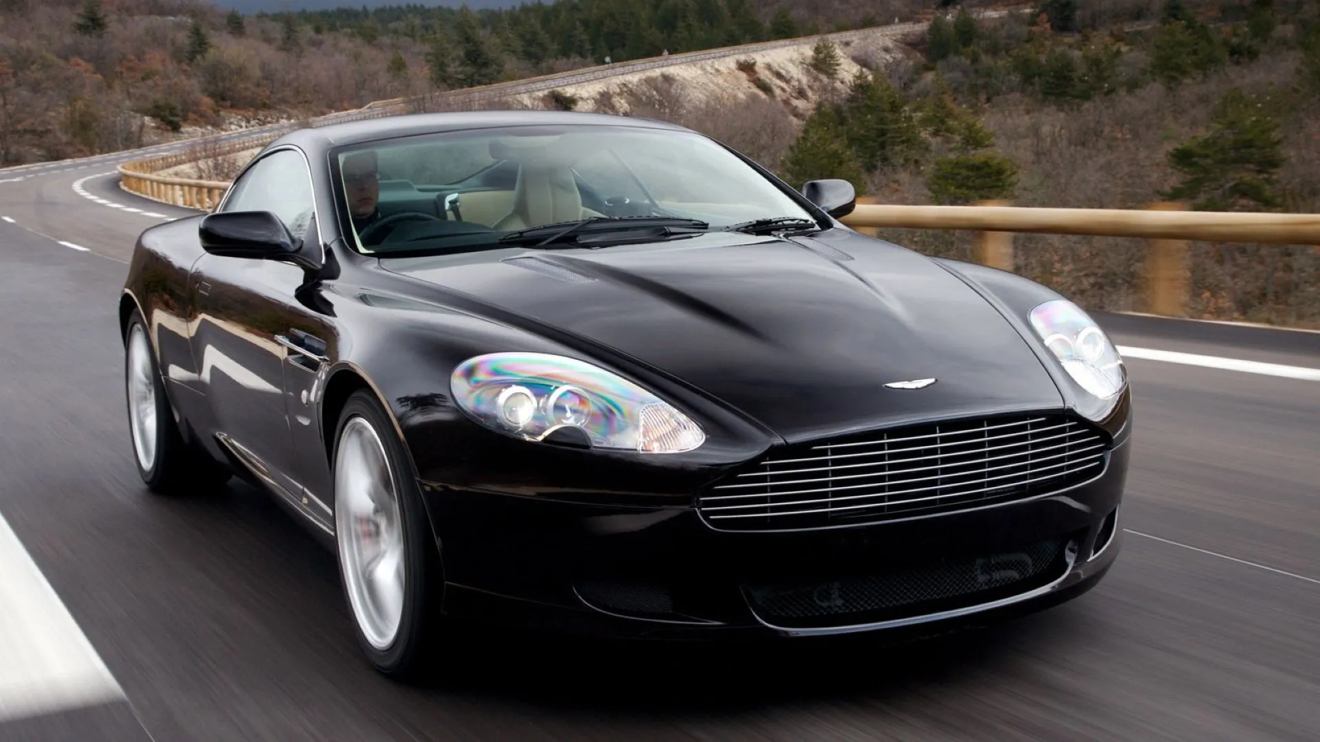 Aston Martin DB9 2007 màu xanh dương đang tăng tốc trên đường
