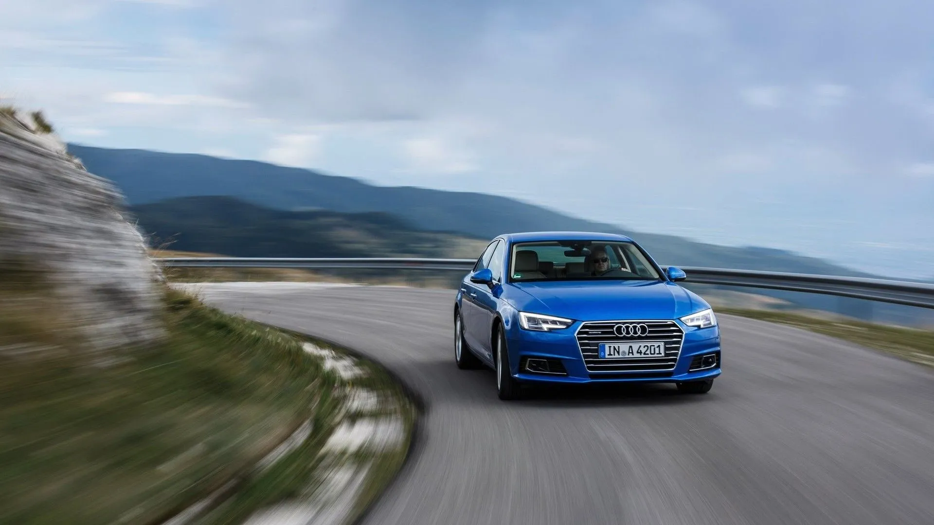 Audi A4 2016 màu trắng đang di chuyển trên đường, nổi bật với thiết kế thể thao năng động và sự kết hợp công nghệ hiện đại.