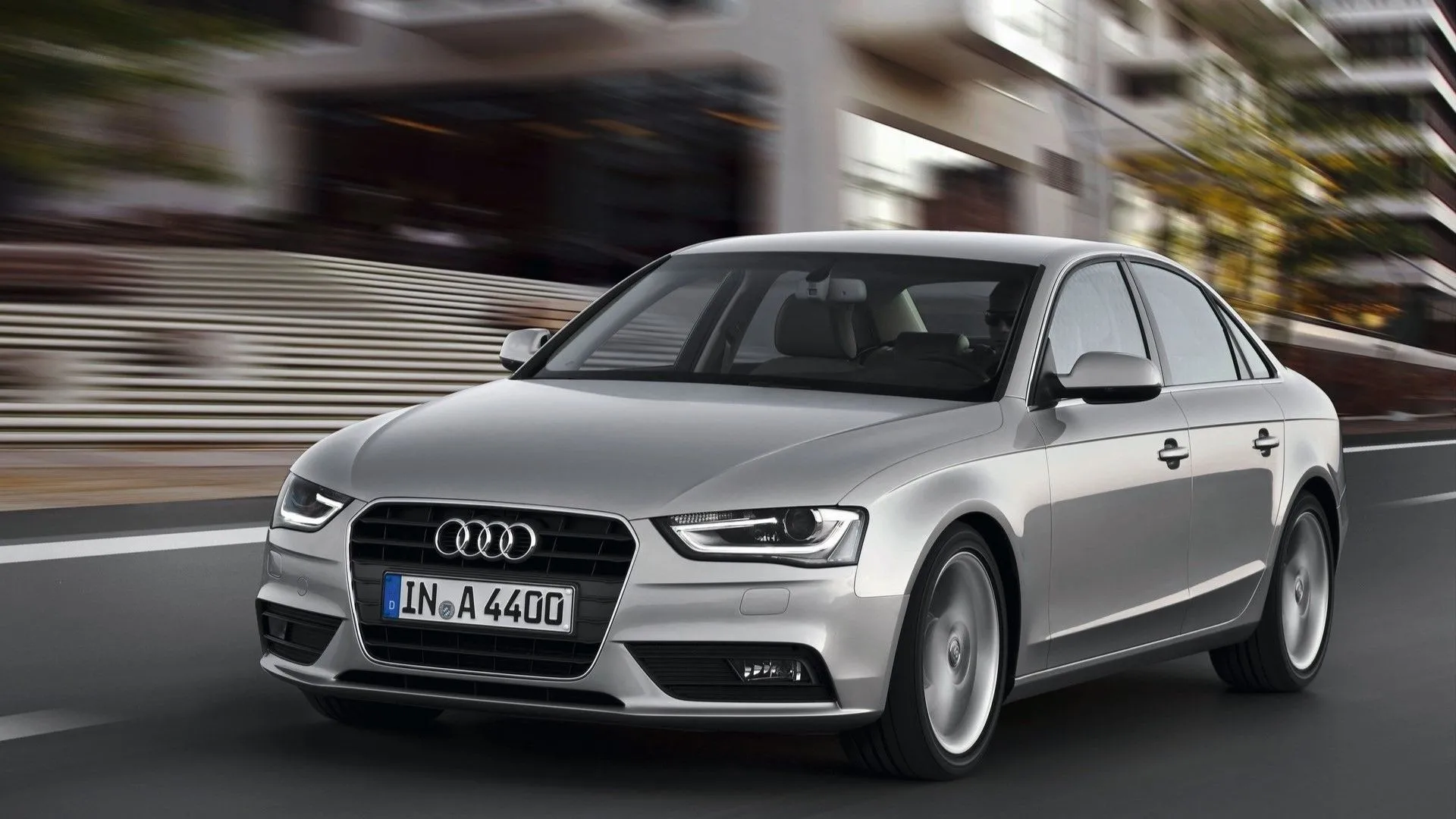 Audi A4 đời 2013 màu xám bạc đang đỗ bên đường, góc chụp 3/4 phía trước