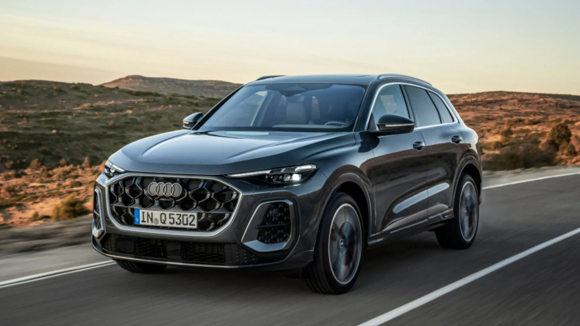 Audi Q5 Premium Plus 45 TFSI Quattro S Tronic 2025 màu xám bạc đang di chuyển trên đường quê, phong cách sang trọng và linh hoạt