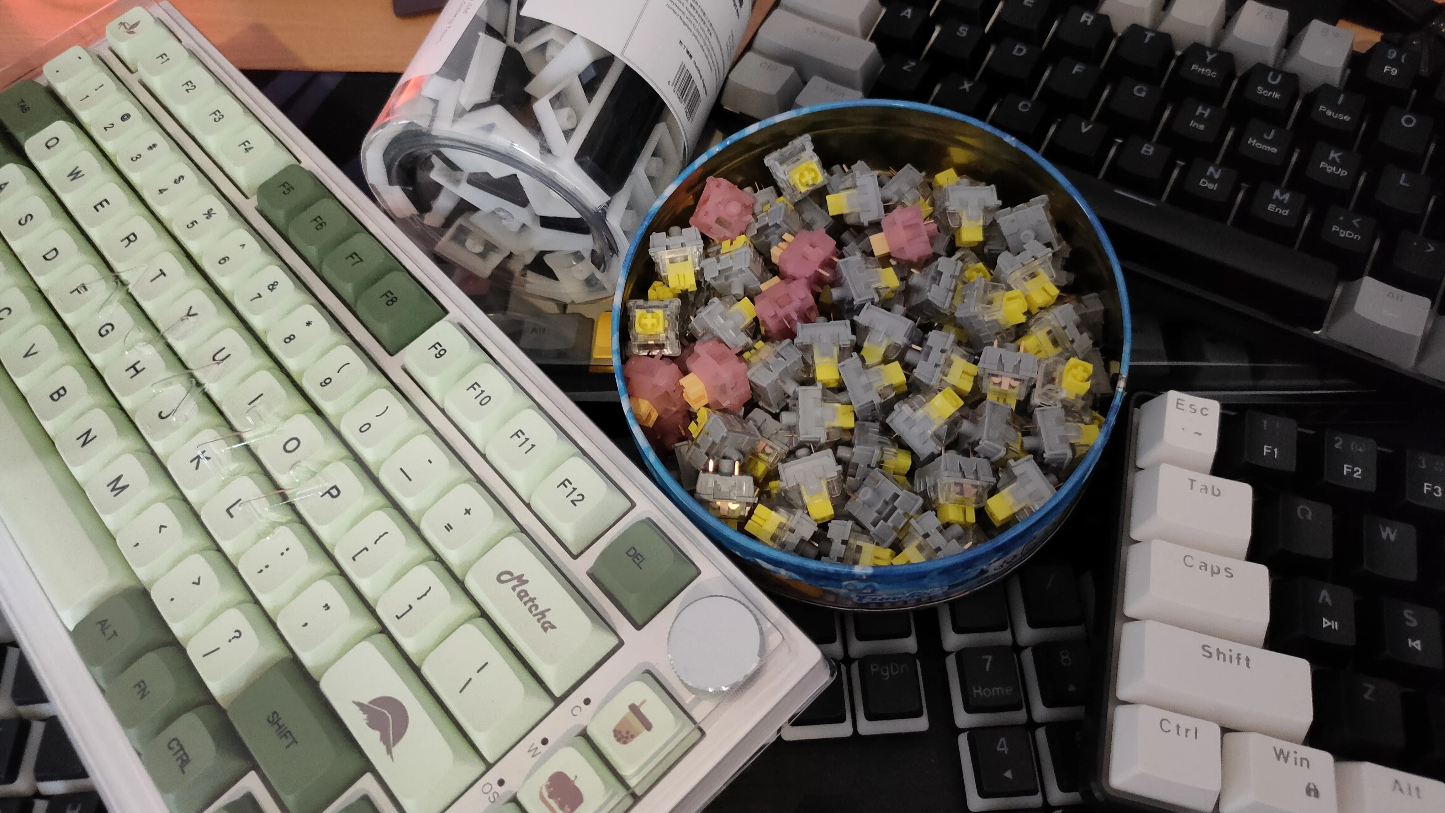 Bàn làm việc với nhiều loại bàn phím, switch và keycap khác nhau, thể hiện văn hóa tùy chỉnh bàn phím cơ