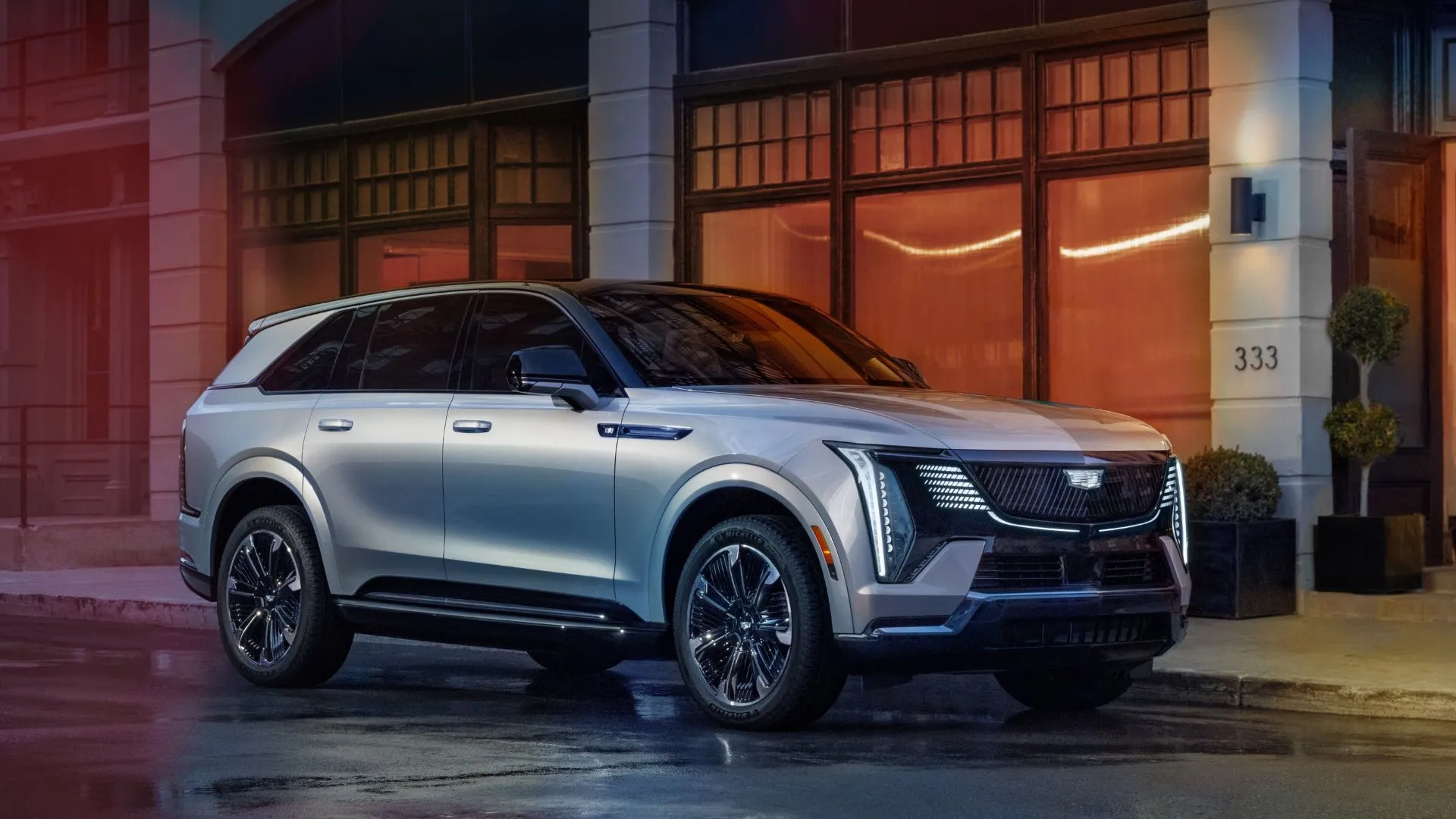 Cadillac Escalade IQ 2025 màu đen đỗ bên lề đường trong thành phố, thể hiện sự sang trọng và hiện đại của SUV điện