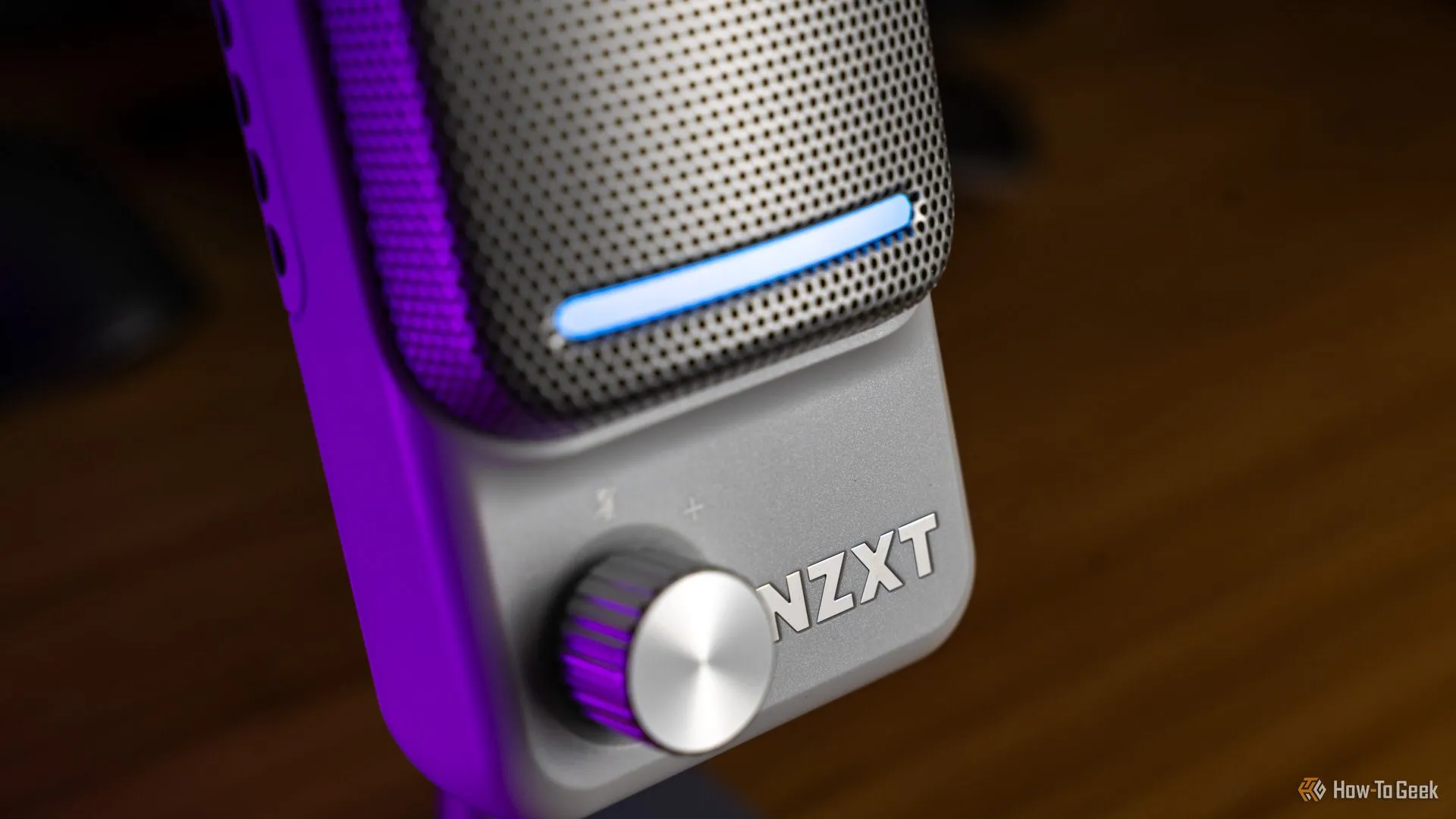 Cận cảnh microphone USB NZXT Capsule Elite màu đen, nổi bật với núm chỉnh gain, dải đèn báo và logo, thích hợp cho gaming và streaming