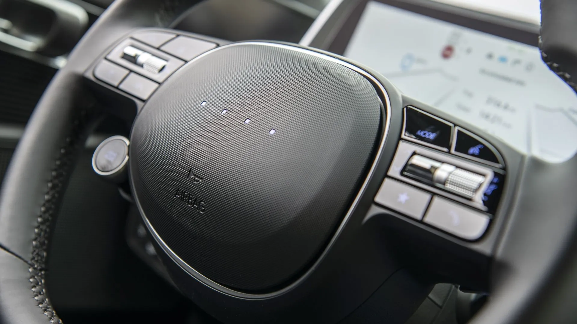 Cận cảnh vô lăng và bảng điều khiển trung tâm của Hyundai Ioniq 6 2025, nổi bật với các nút bấm vật lý và màn hình kép liền mạch.