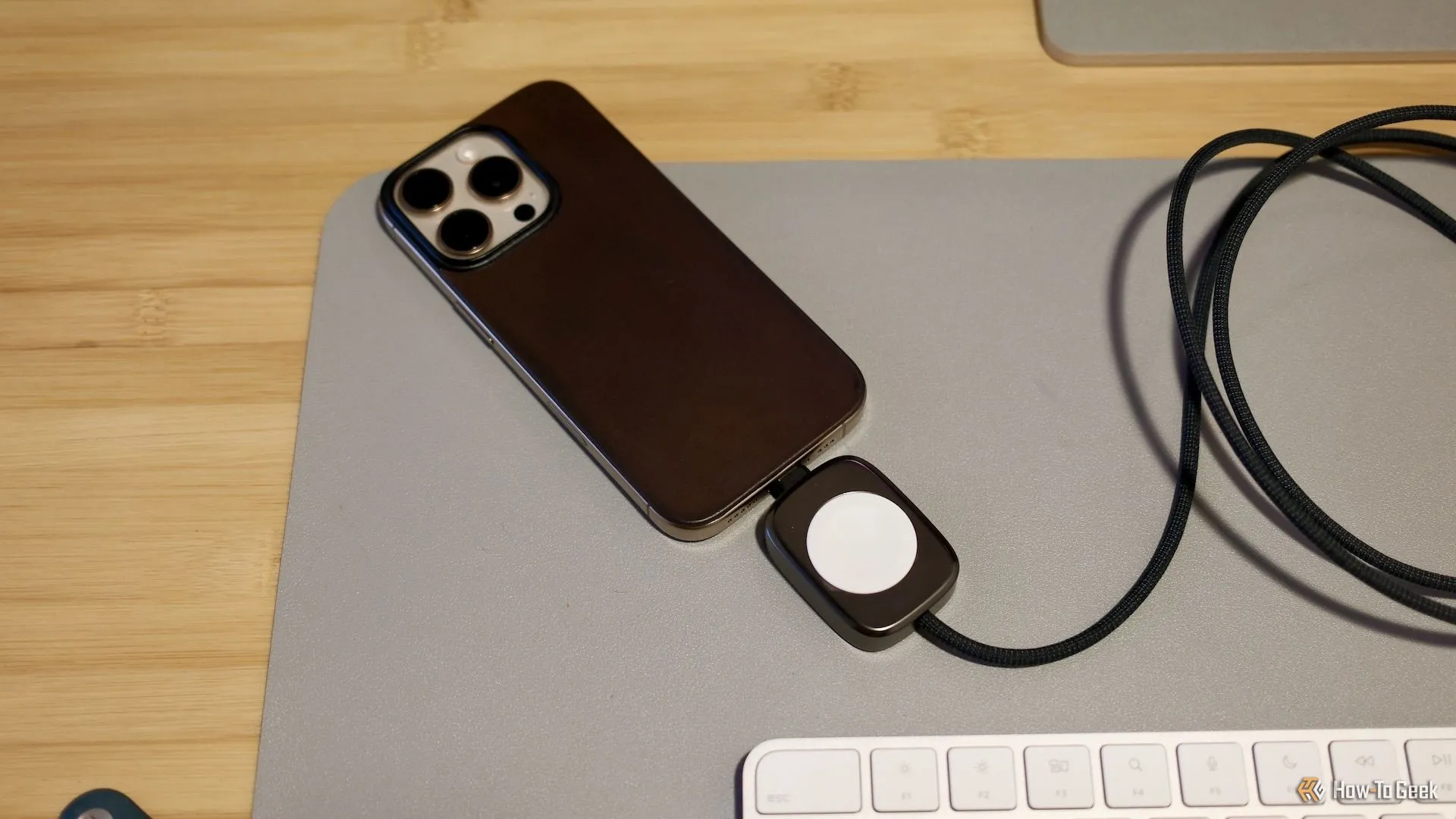 Cáp sạc Nomad Universal Apple Watch 2 trong 1 trên bàn làm việc với cổng USB-C và sạc MagSafe
