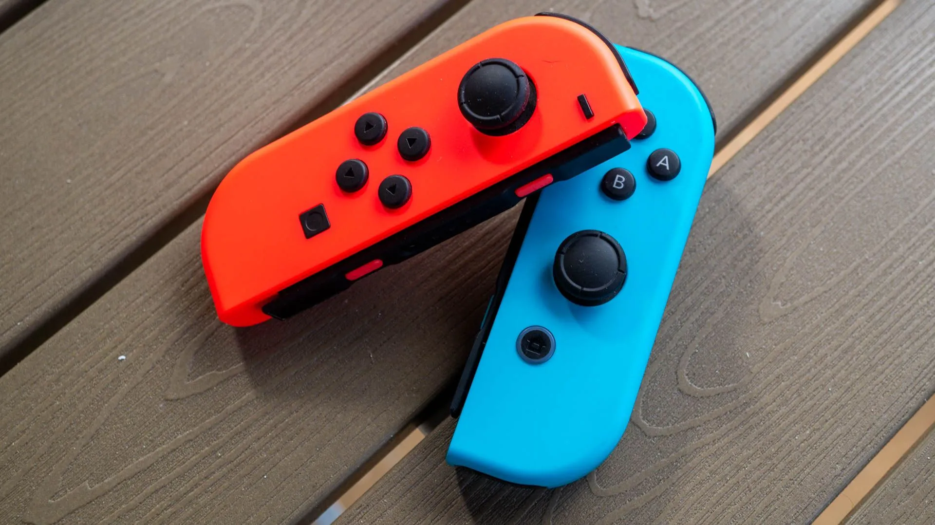 Cặp tay cầm Joy-Con màu xanh và đỏ của Nintendo Switch đặt trên bàn