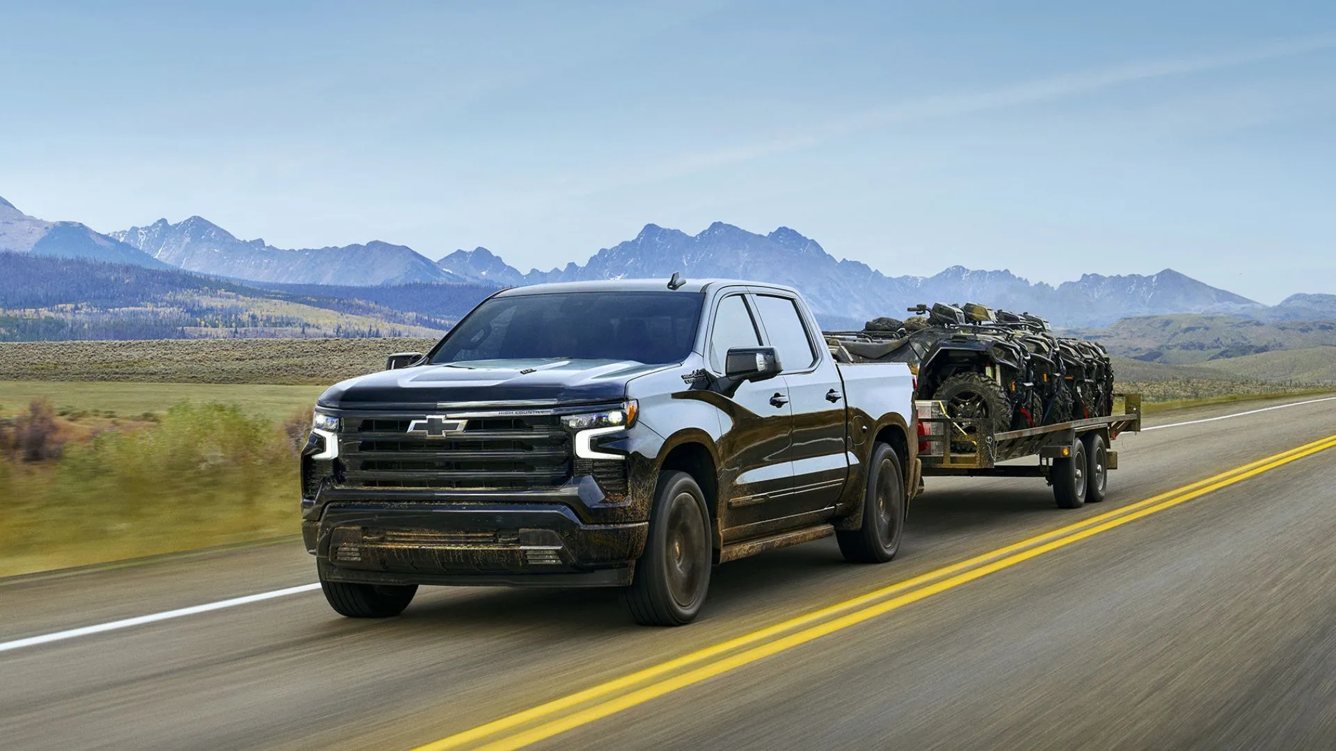 Chevrolet Silverado 2025 màu đen kéo rơ-moóc trên đường nông thôn, thể hiện sức mạnh