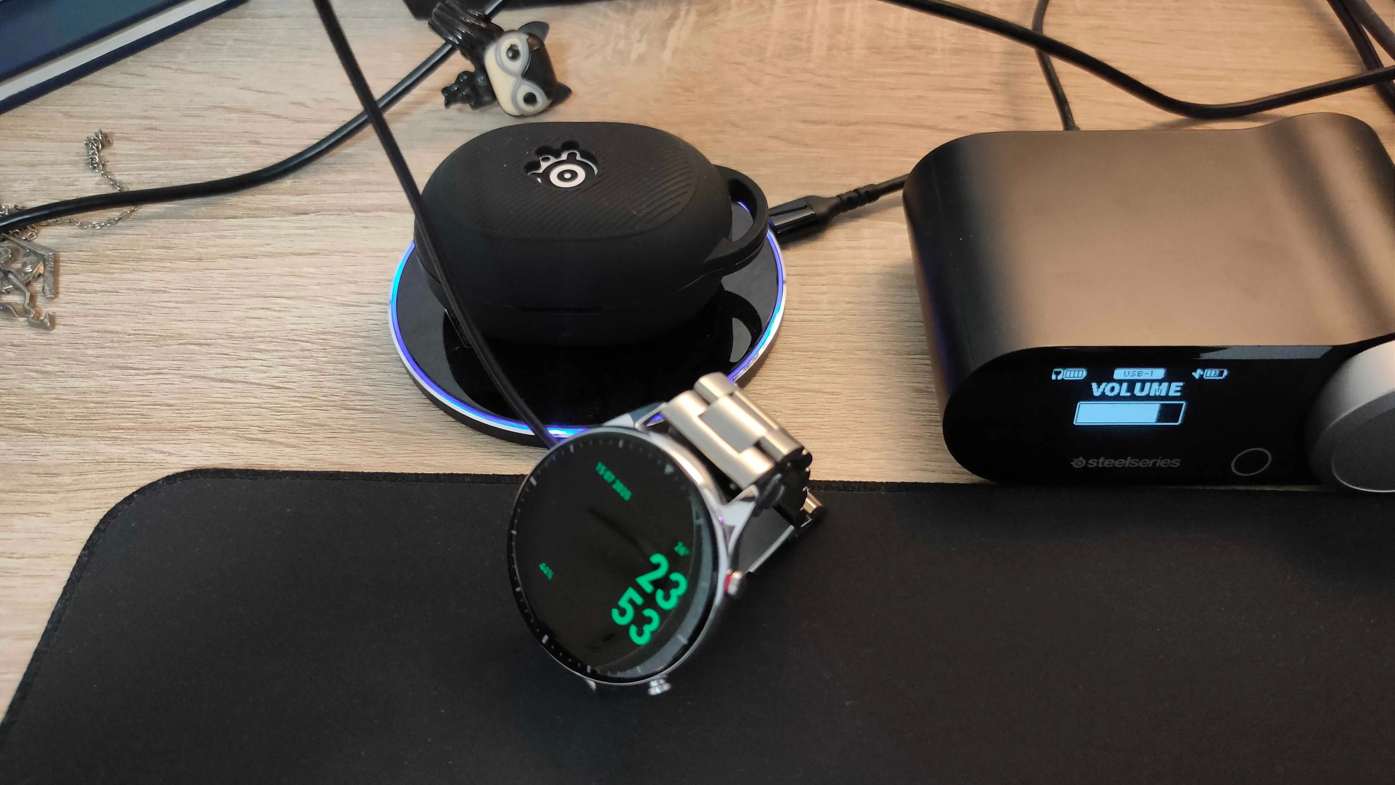 Đồng hồ thông minh Amazfit GTR 2 và tai nghe SteelSeries Arctis GameBuds đang được sạc qua cổng USB của màn hình