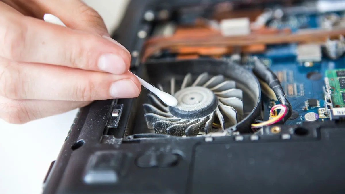 Dùng tăm bông vệ sinh các khe hở và quạt tản nhiệt laptop bị bám bụi