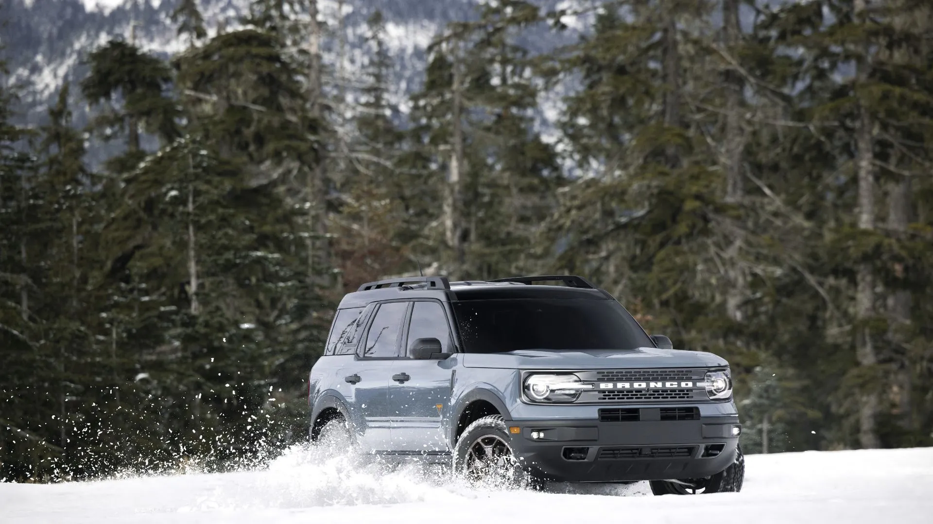 Ford Bronco Sport 2022 màu xám đang off-road trong tuyết, góc nhìn ba phần tư phía trước.