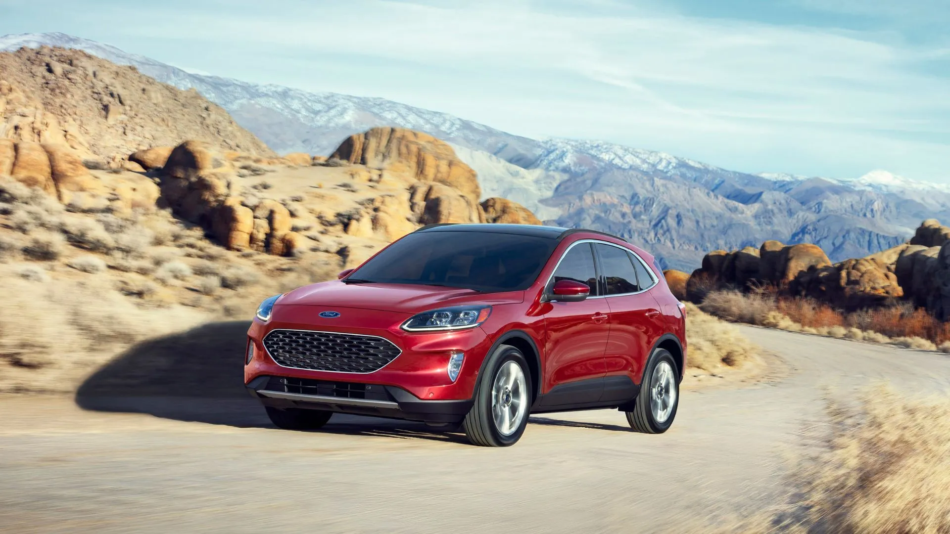 Ford Escape Hybrid 2020 màu đỏ đang lên dốc trên con đường nông thôn quanh co, nhấn mạnh khả năng vận hành linh hoạt và tiết kiệm nhiên liệu.