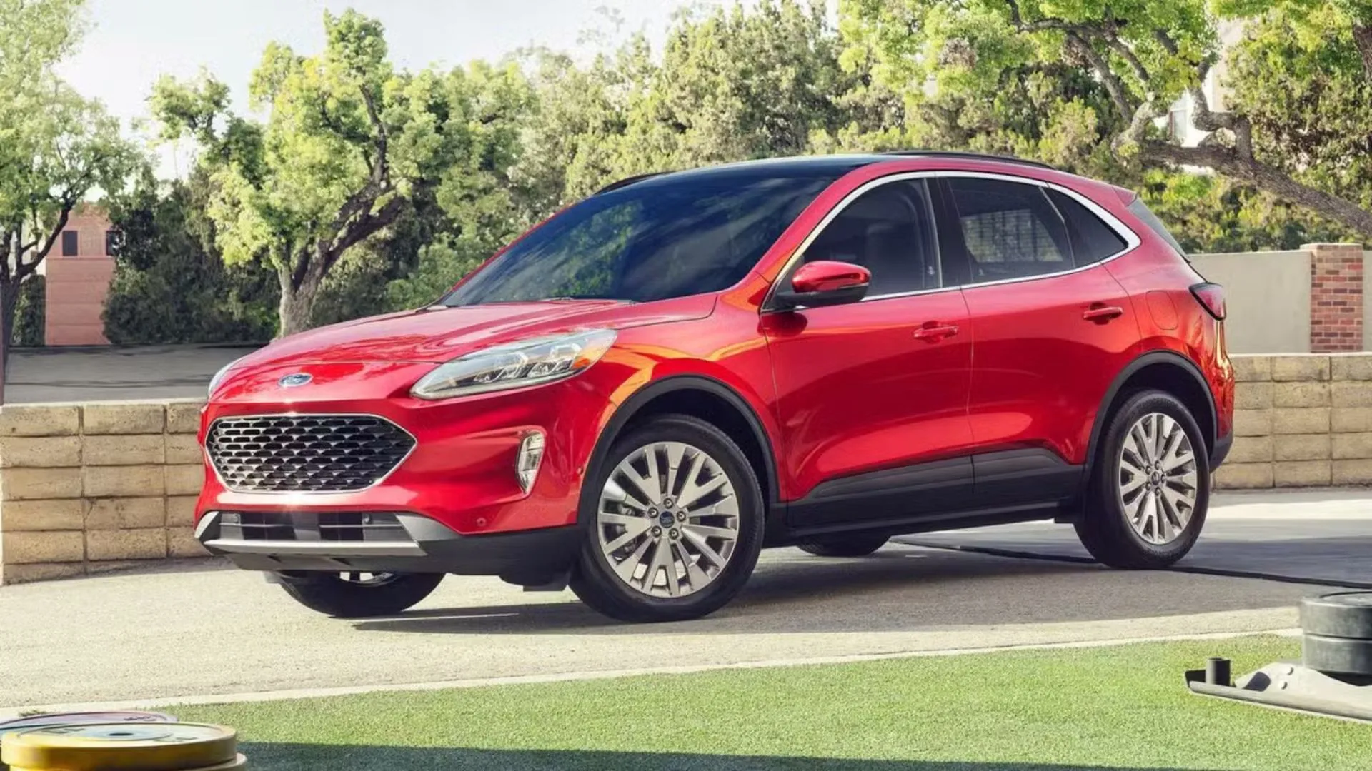 Ford Escape PHEV 2022 màu đỏ đỗ trong sân, cho thấy hình ảnh quen thuộc của một chiếc SUV gia đình tiết kiệm nhiên liệu.
