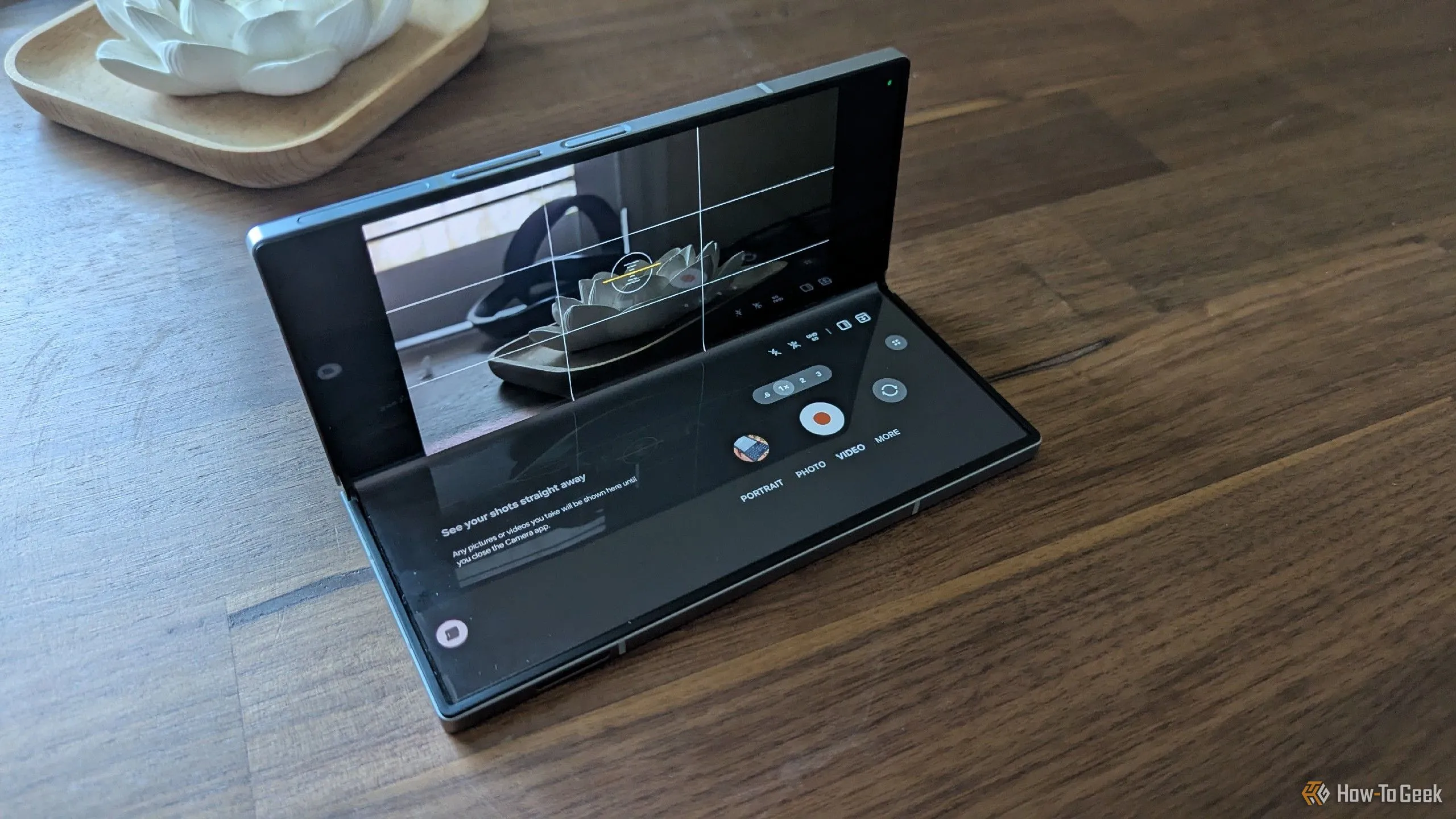 Galaxy Z Fold 6 được gập một góc và đặt trên bề mặt phẳng, minh họa khả năng tự đóng vai trò như một chân máy di động khi chụp ảnh.