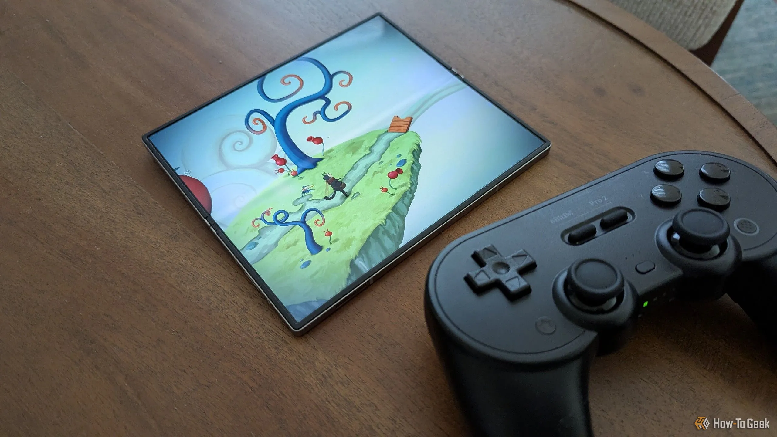 Game Figment đầy màu sắc đang chạy trên Samsung Galaxy Z Fold 6, đặt cạnh tay cầm 8BitDo Pro 2, thể hiện khả năng chơi game di động chất lượng cao