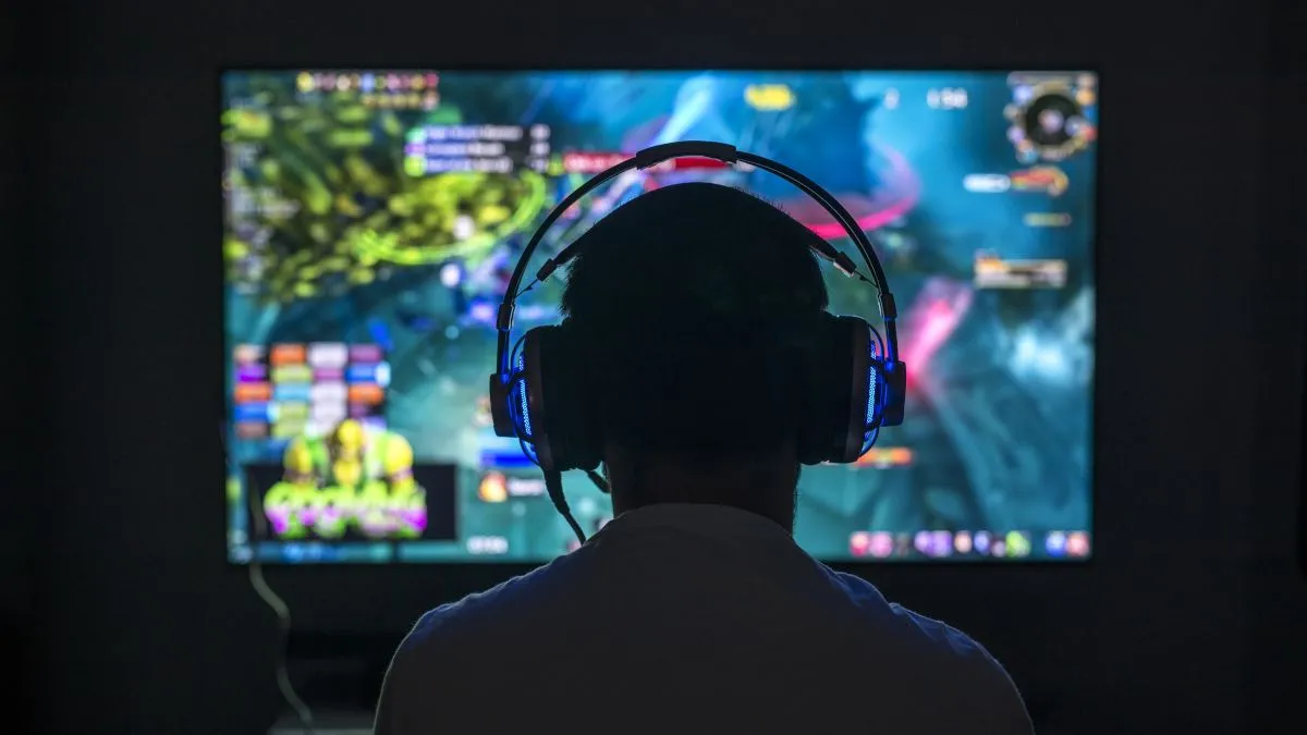 Game thủ với tai nghe và màn hình tần số quét cao