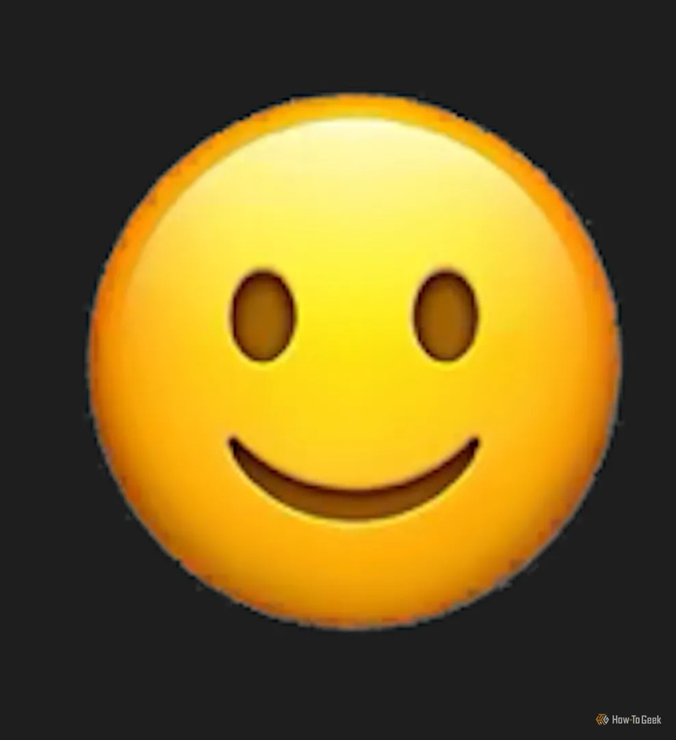 Genmoji biểu tượng cảm xúc mặt cười rộng đáng sợ với đôi mắt vô hồn, tạo cảm giác uncanny valley từ AI của Apple.